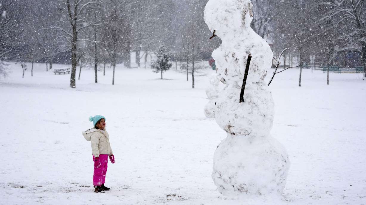 Brooklyn Brye, 4, looks up at a giant snowman, in Nashville, Tenn., Friday.