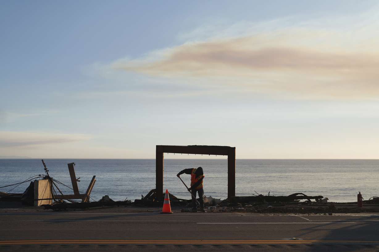 A worker clears debris from the Palisades Fire on Friday in Malibu, Calif.