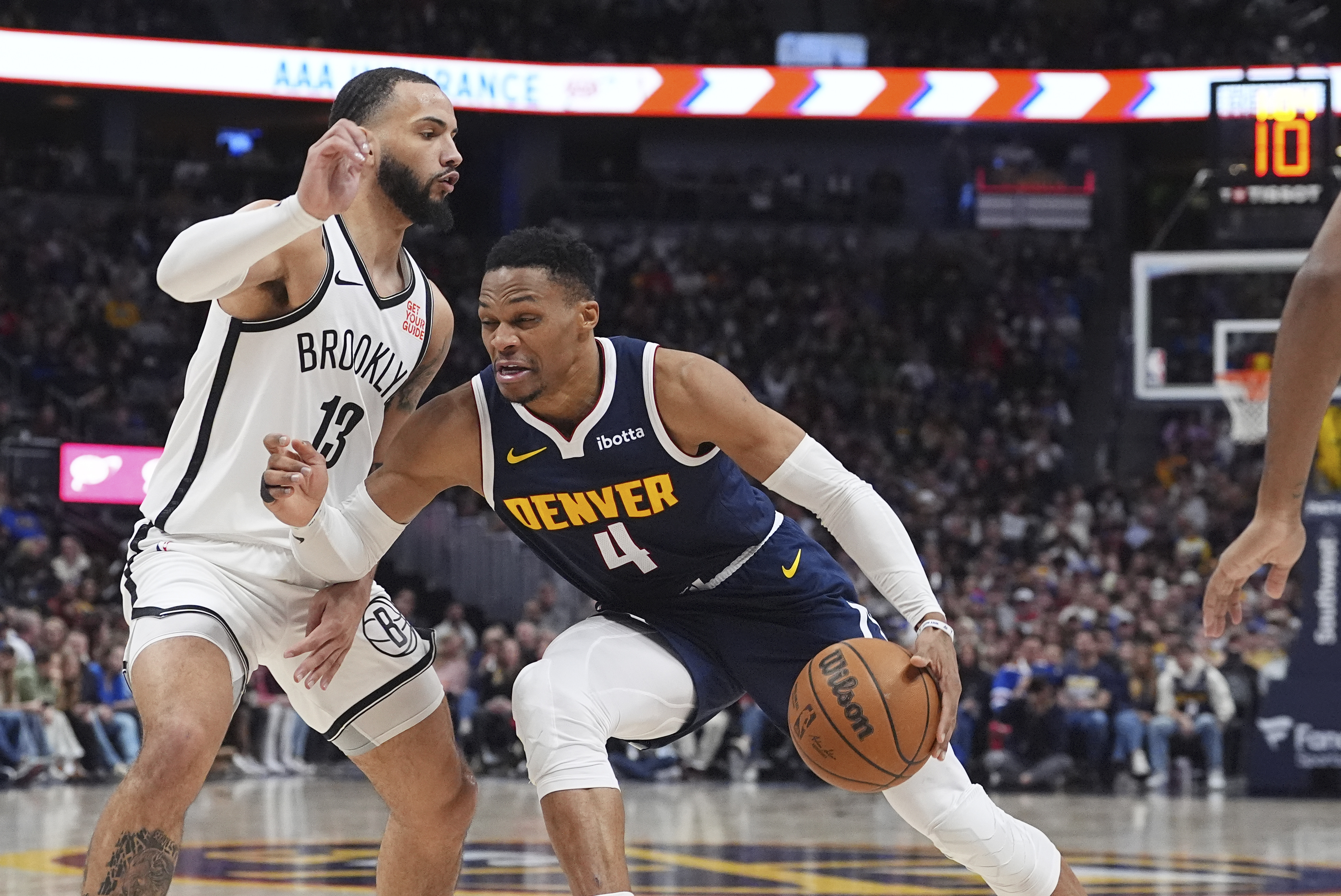 Denver Nuggets guard Russell Westbrook (4) drives to the basket as Brooklyn Nets guard Tyrese Martin (13) defends in the second half of an NBA basketball game Friday, Jan. 10, 2025, in Denver.