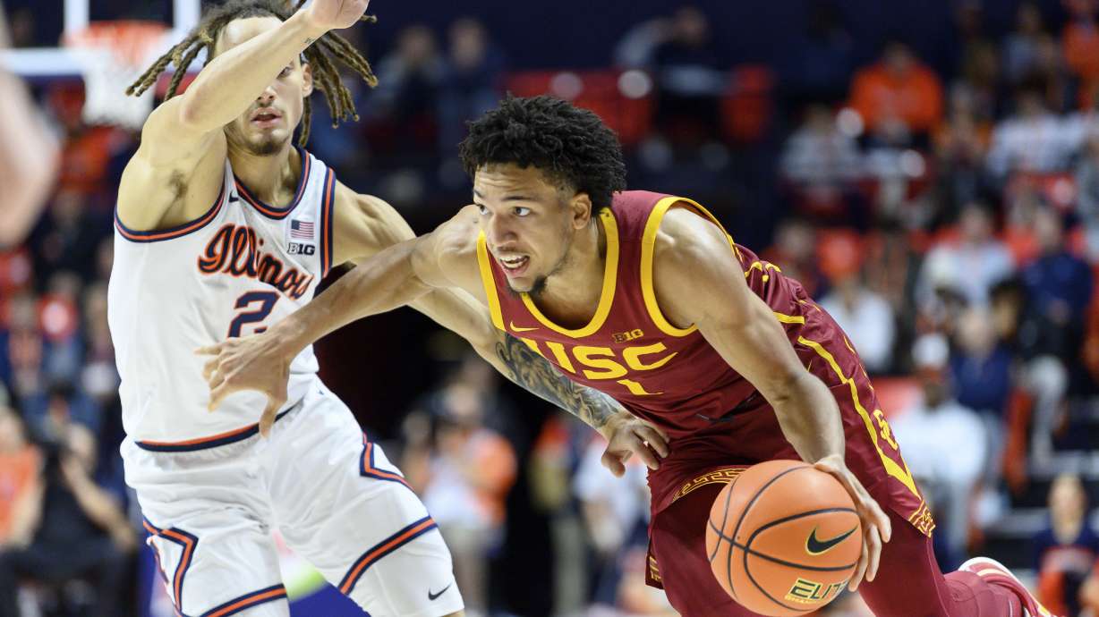 Southern California's Desmond Claude, right, drives on Illinois' Dra Gibbs-Lawhorn during the second half of an NCAA college basketball game Saturday, Jan. 11, 2025, in Champaign, Ill.