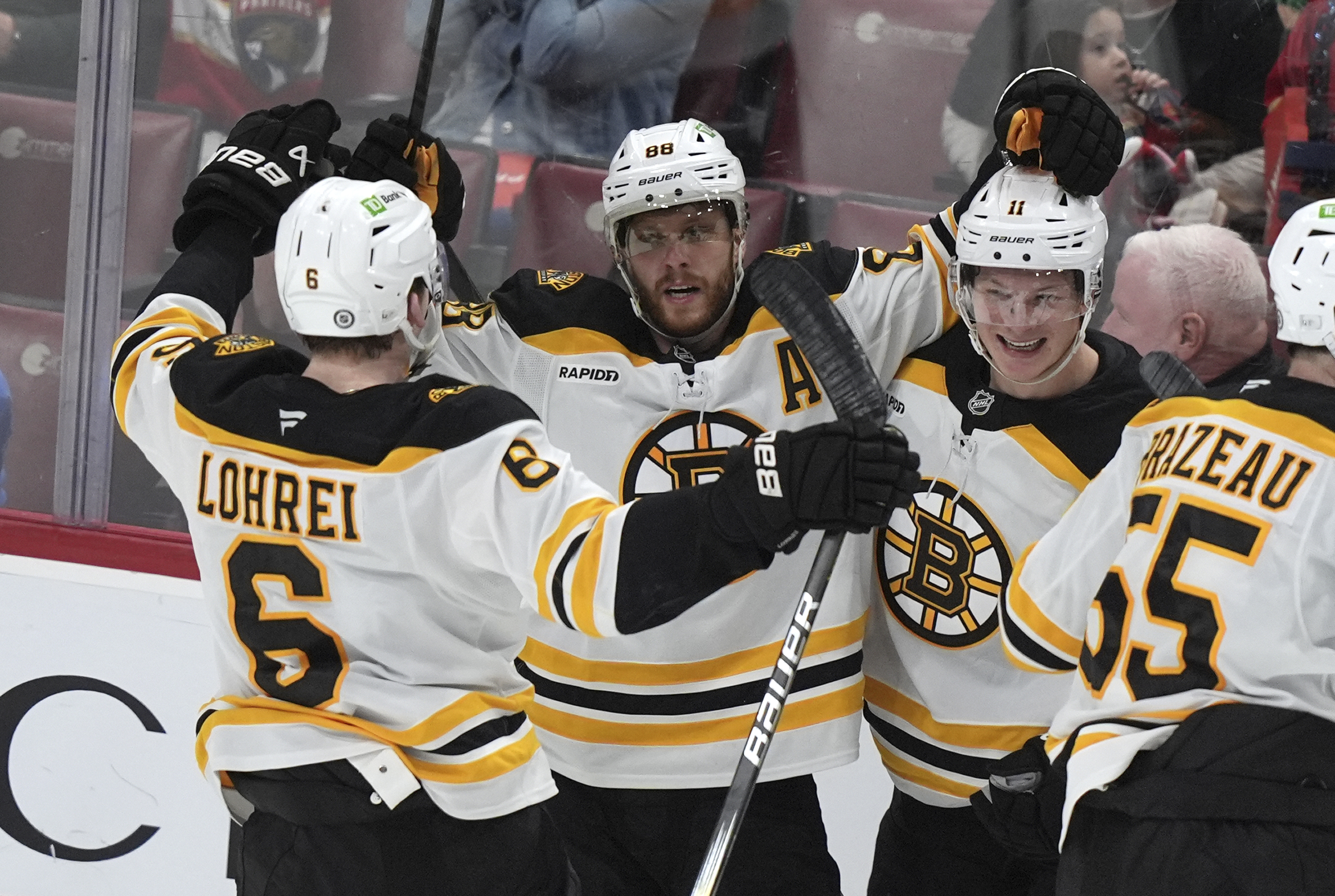 Boston Bruins right wing David Pastrnak (88) celebrates with teammates after scoring the game-winning goal during overtime of an NHL hockey game against the Florida Panthers, Saturday, Jan. 11, 2025, in Sunrise, Fla. 