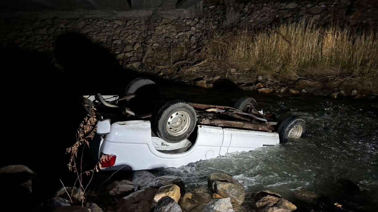 A truck submerged in the Spanish Fork River after the driver was rescued by bystanders and taken to the hospital Friday night.