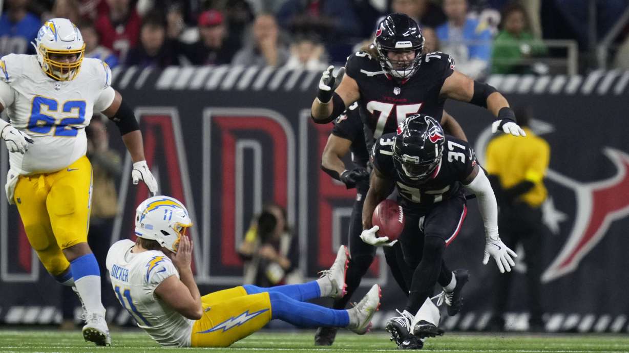 Houston Texans' D'Angelo Ross (37) returns a blocked extra-point attempt by Los Angeles Chargers place kicker Cameron Dicker (11) for two-points during the second half of an NFL wild-card playoff football game Saturday, Jan. 11, 2025, in Houston.