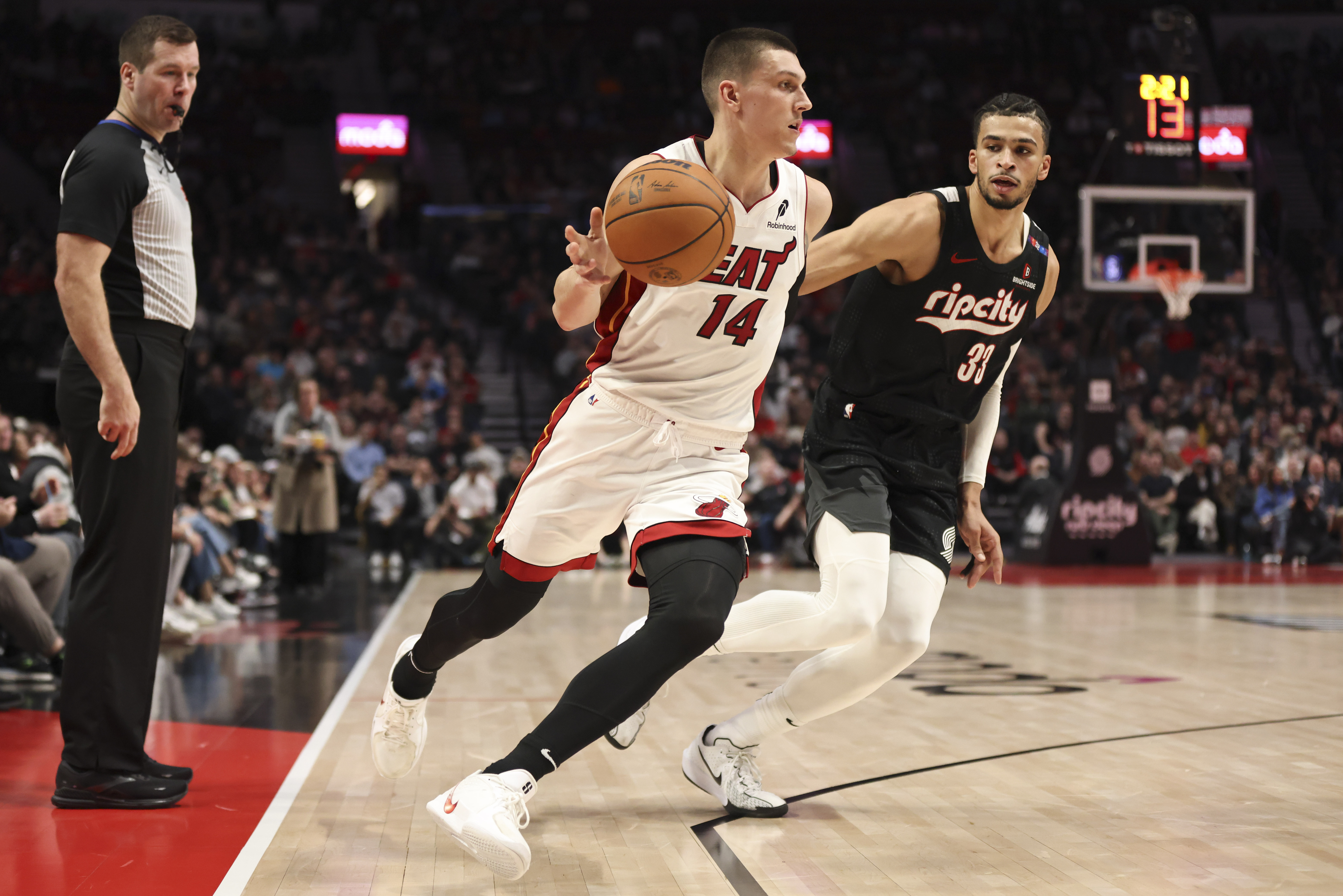 Miami Heat guard Tyler Herro (14) brings the ball up court as Portland Trail Blazers forward Toumani Camara (33) defends during the first half of an NBA basketball game Saturday, Jan. 11, 2025, in Portland, Ore.