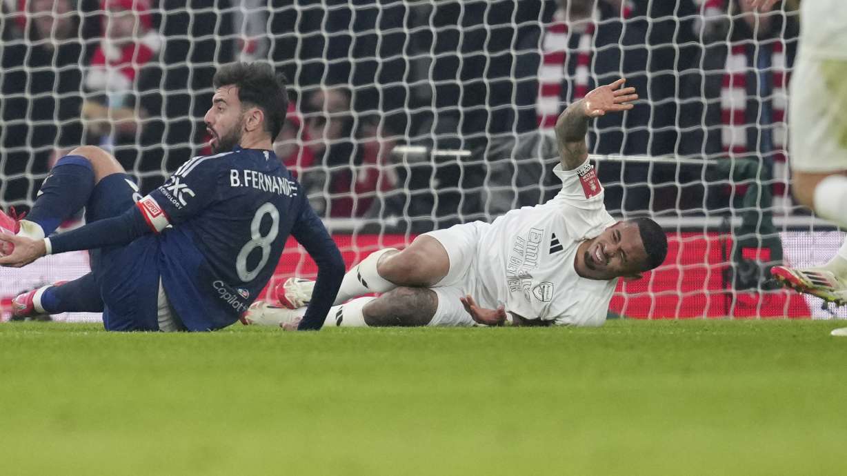 Arsenal's Gabriel Jesus, bottom right, reacts after injuring during the English FA Cup soccer match between Arsenal and Manchester United at the Emirates stadium in London, Sunday, Jan. 12, 2025.