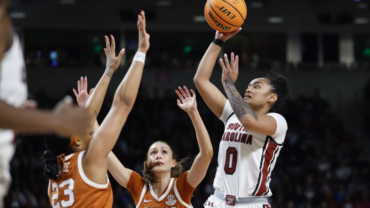 South Carolina guard Te-Hina Paopao (0) shoots over Texas forward Aaliyah Moore (23) as guard Shay Holle, center, looks on during the first half of an NCAA college basketball game in Columbia, S.C., Sunday, Jan. 12, 2025.