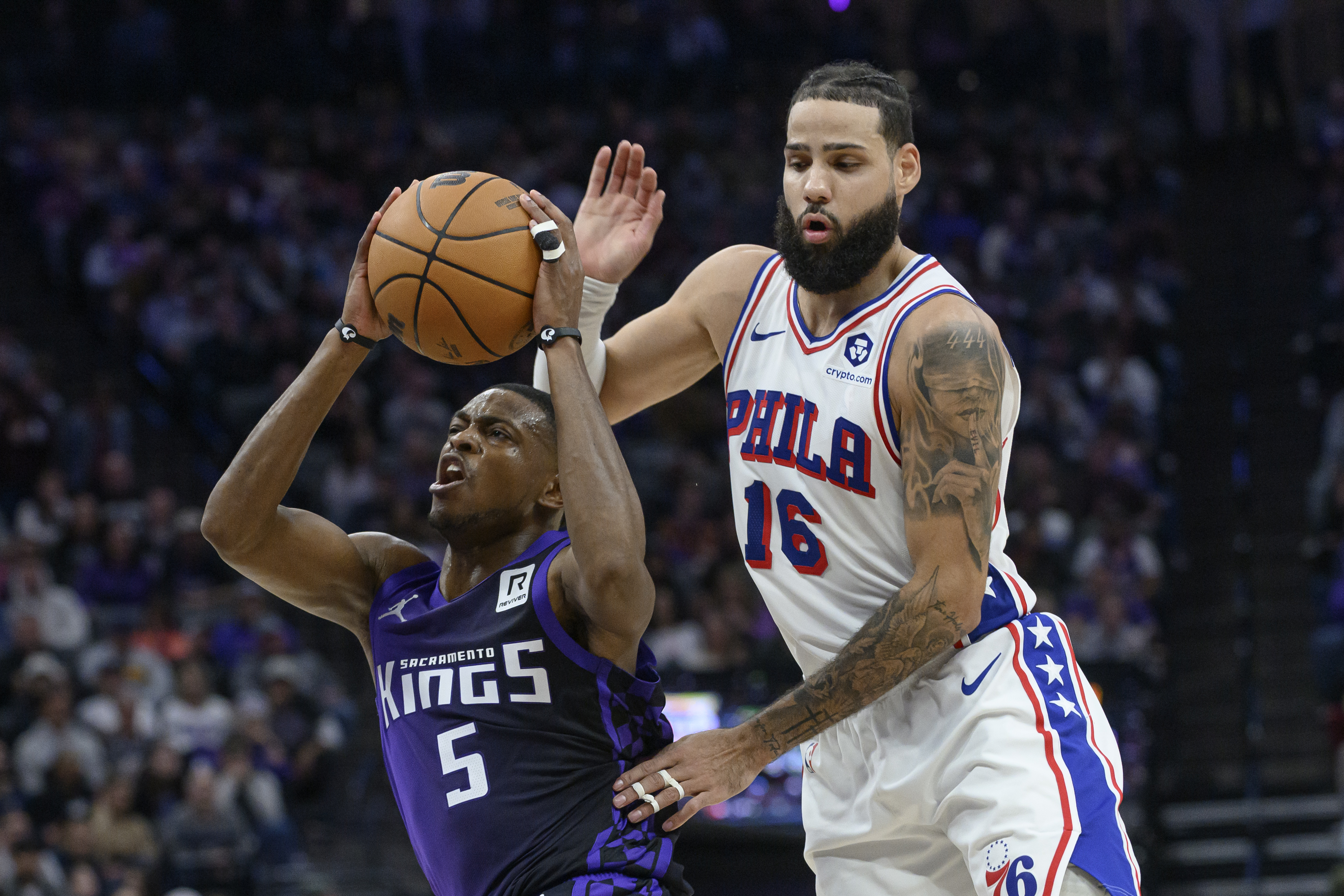 Sacramento Kings guard De'Aaron Fox (5) drives past Philadelphia 76ers forward Caleb Martin (16) during the second half of an NBA basketball game in Sacramento, Calif., Wednesday, Jan. 1, 2025. The Kings won 113-107.