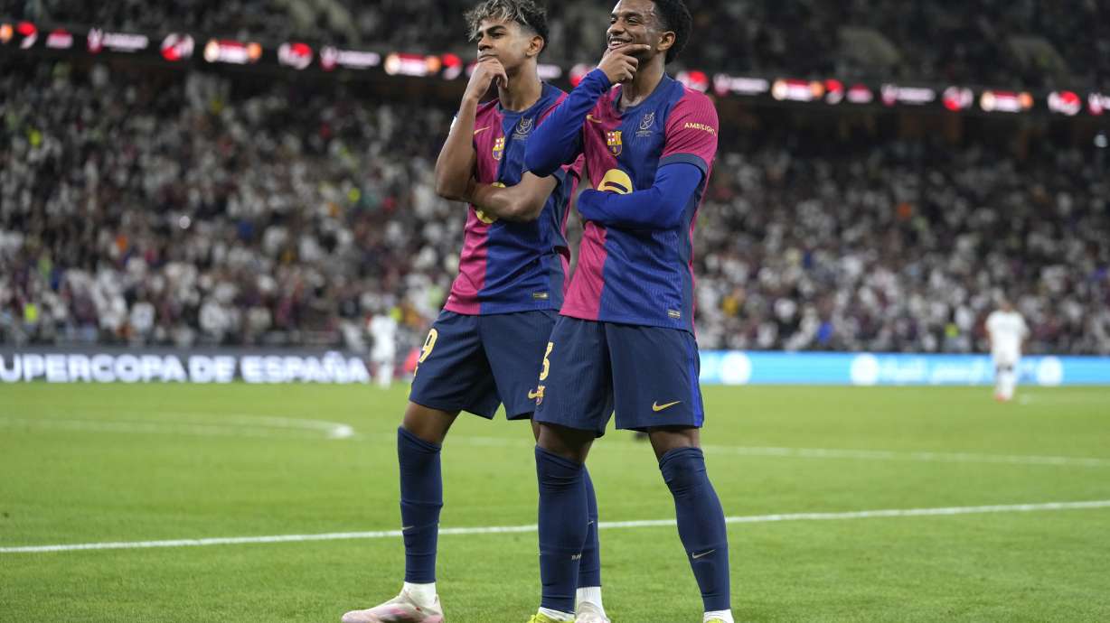 Barcelona's Alejandro Balde, right, and Barcelona's Lamine Yamal react during the Spain Super Cup final soccer match between Real Madrid and Barcelona at King Abdullah Stadium in Jeddah, Saudi Arabia, Sunday, Jan. 12, 2025.