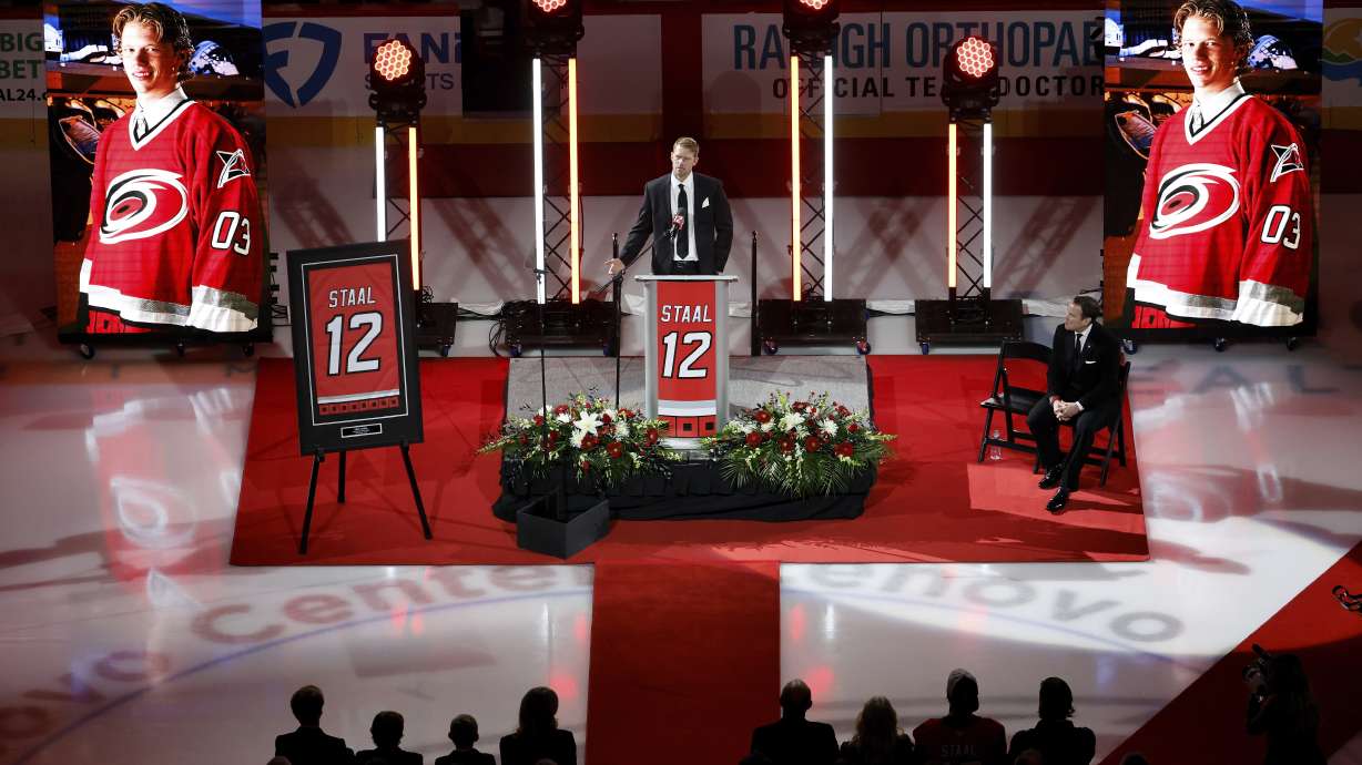 Former Carolina Hurricanes player Eric Staal, center, speaks during a ceremony to retire his No. 12 jersey prior an NHL hockey game against the Anaheim Ducks in Raleigh, N.C., Sunday, Jan. 12, 2025.