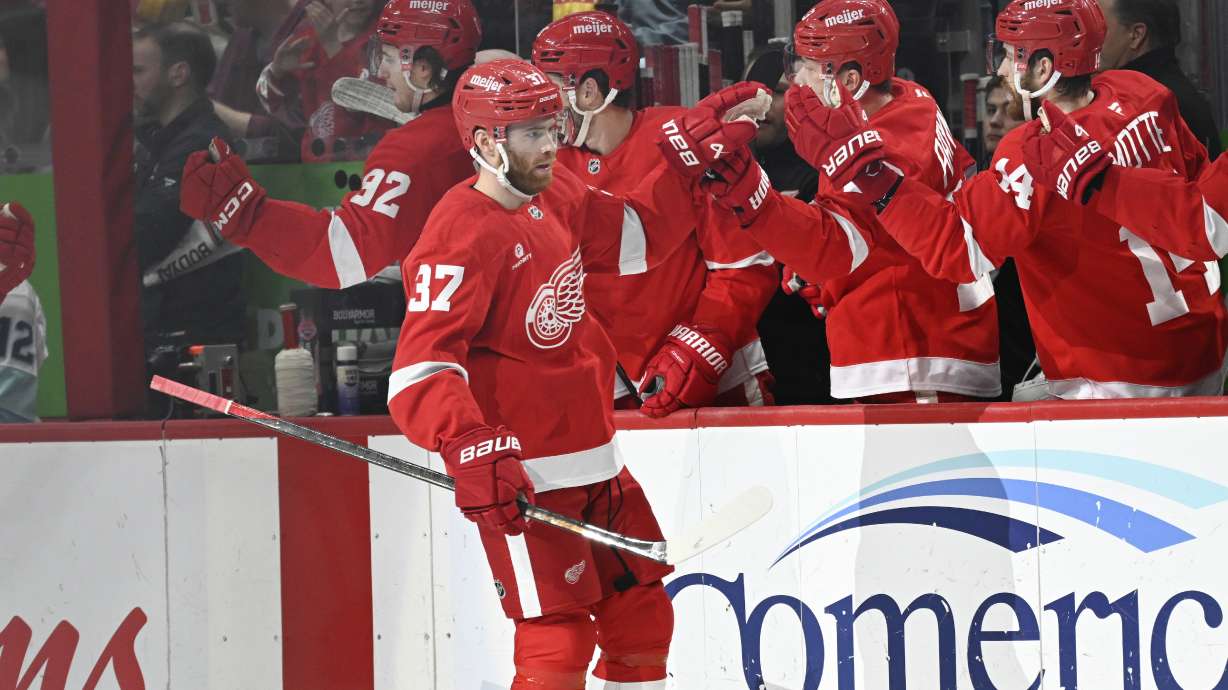 Detroit Red Wings left wing J.T. Compher is congratulated by teammates after scoring a goal against the Seattle Kraken during the first period of an NHL hockey game, Sunday, Jan. 12, 2025, in Detroit.