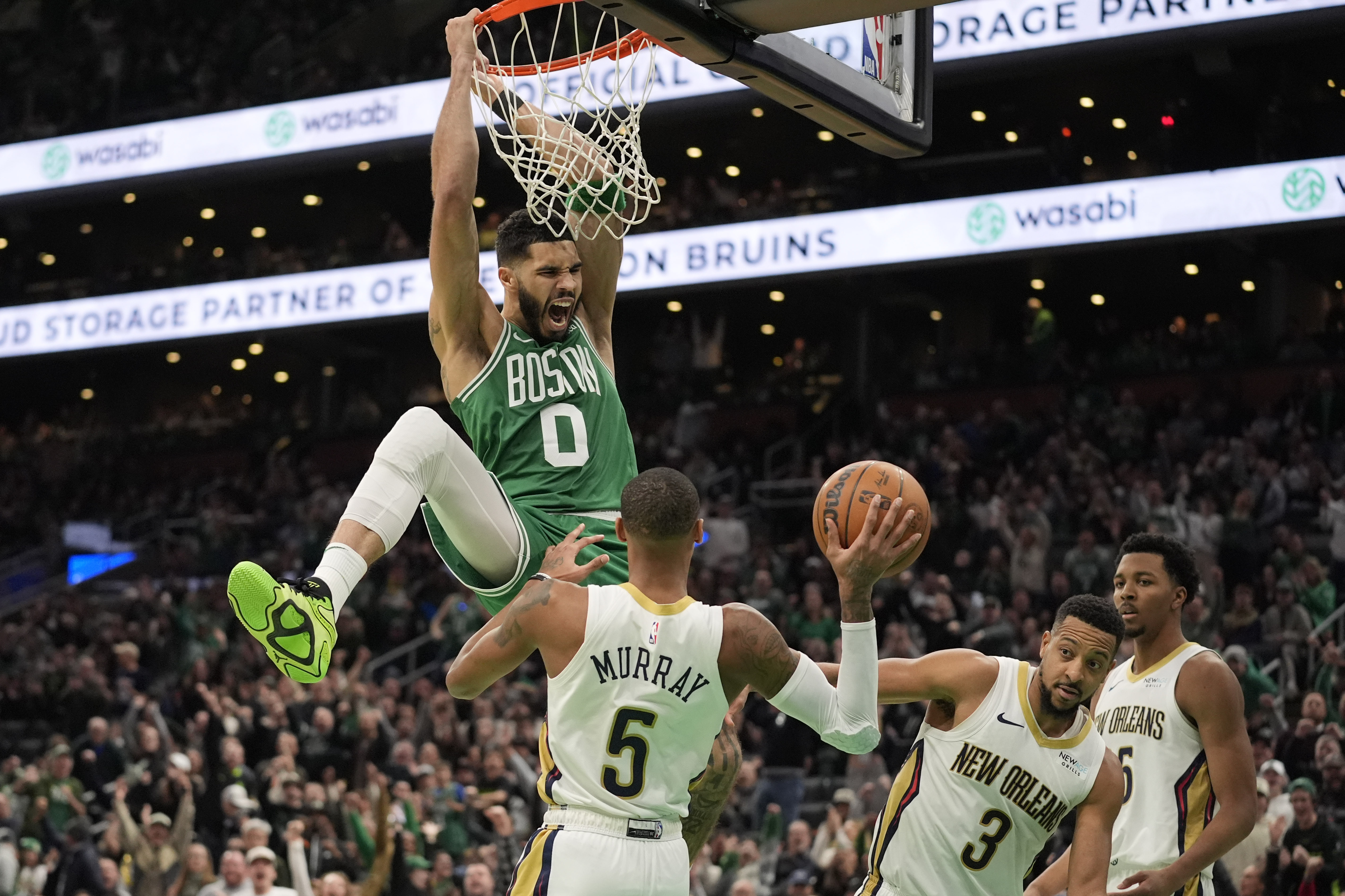 Boston Celtics' Jayson Tatum (0) screams after dunking on New Orleans Pelicans' Dejounte Murray (5), CJ McCollum (3) and Trey Murphy III (25) during the second half of an NBA basketball game, Sunday, Jan. 12, 2025, in Boston.