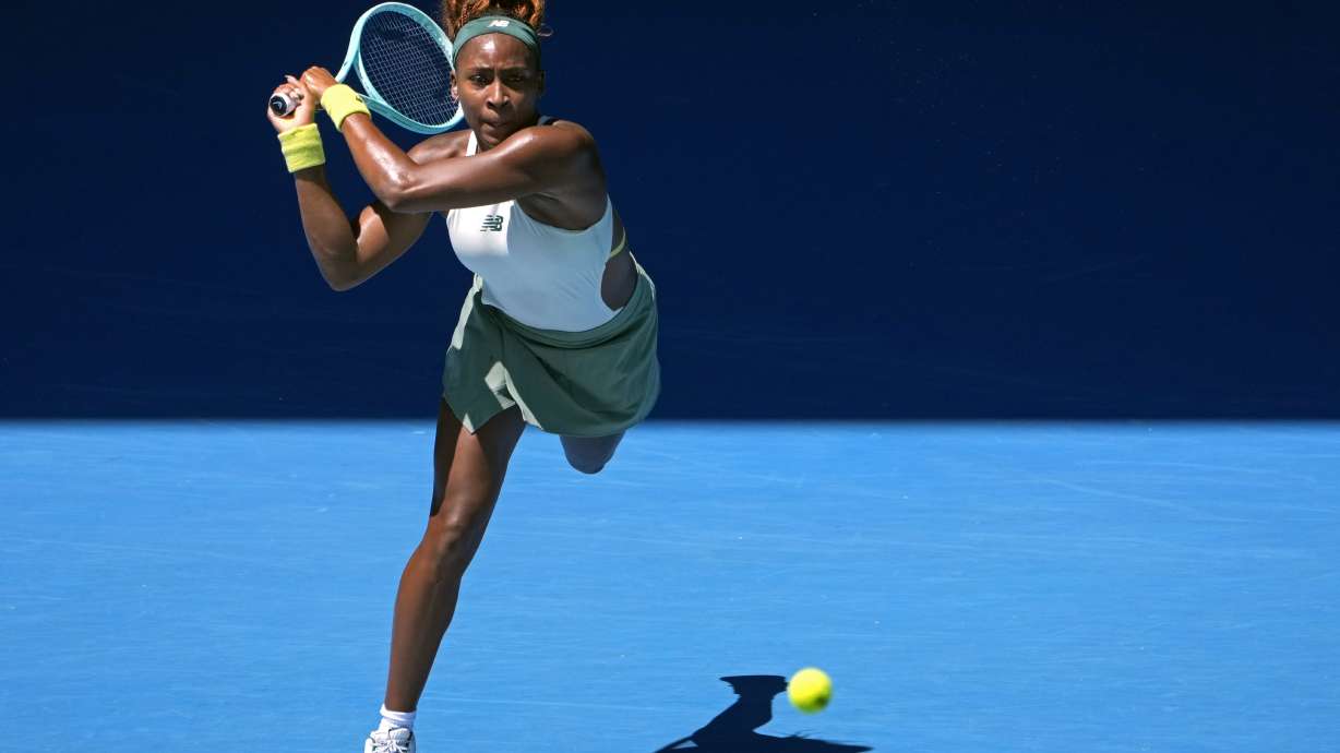 Coco Gauff of the U.S. plays a backhand return to Sofia Kenin of the U.S. during their first round match at the Australian Open tennis championship in Melbourne, Australia, Monday, Jan. 13, 2025.