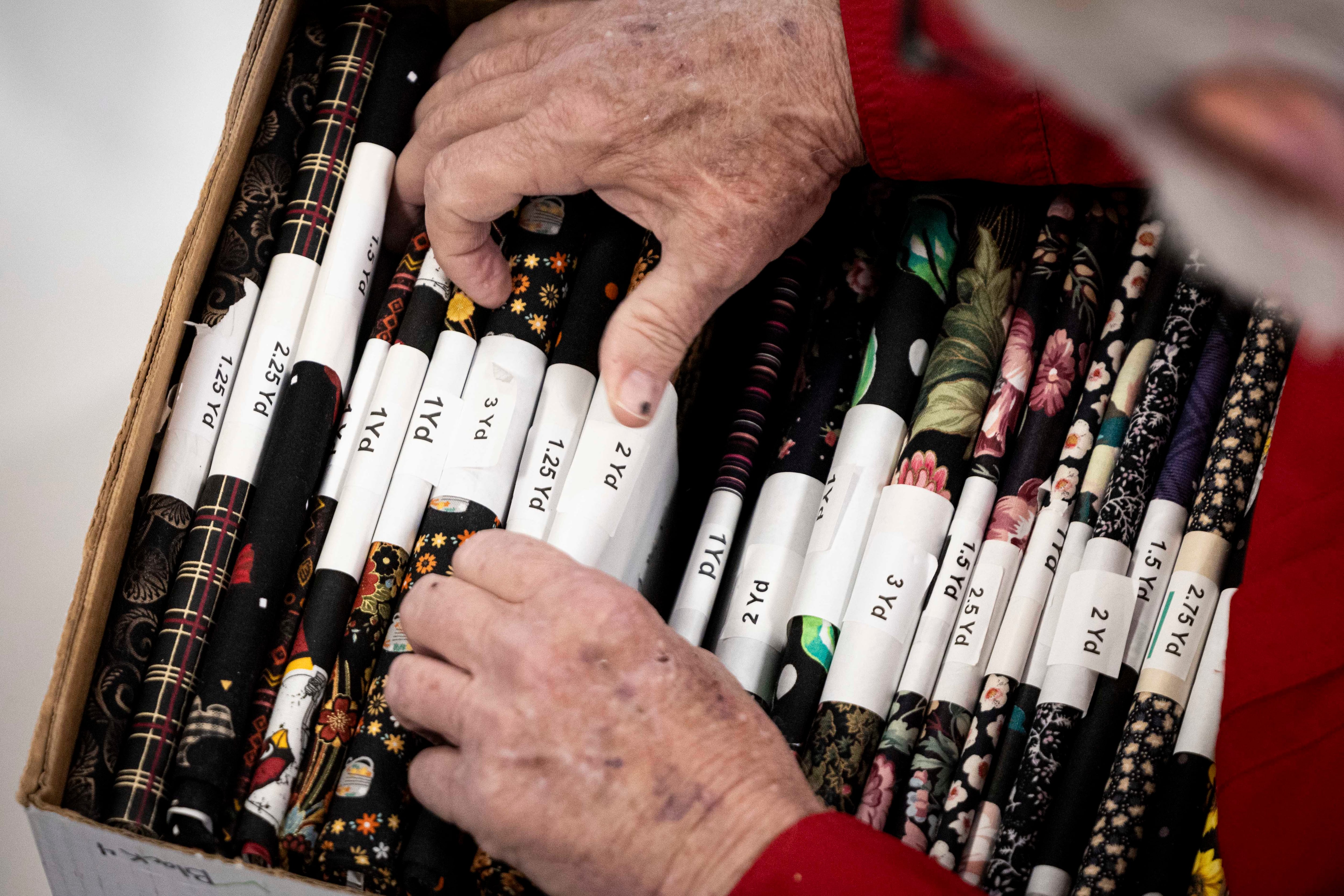 Barry Dill, a volunteer from Asphalt Zipper, catalogs fabrics at Stitching Hearts Worldwide’s headquarters in Pleasant Grove on Jan. 7.