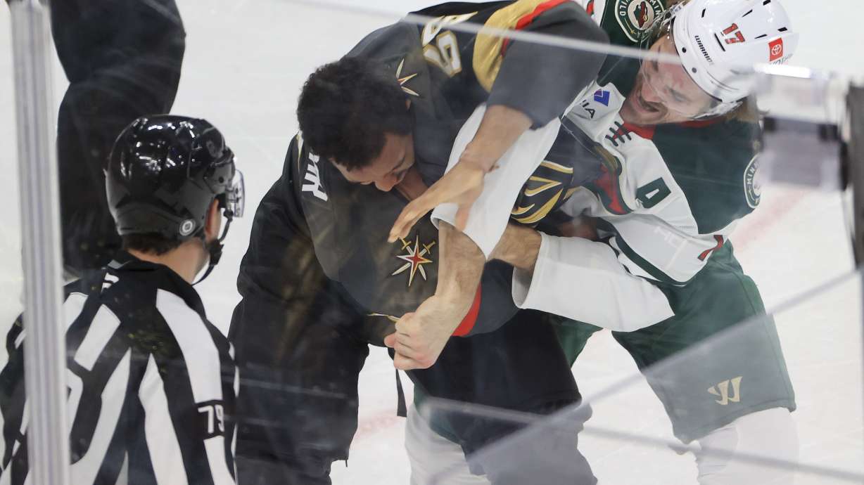 Vegas Golden Knights right wing Keegan Kolesar (55) and Minnesota Wild left wing Marcus Foligno (17) fight during the first period of an NHL hockey game Sunday, Jan. 12, 2025, in Las Vegas.