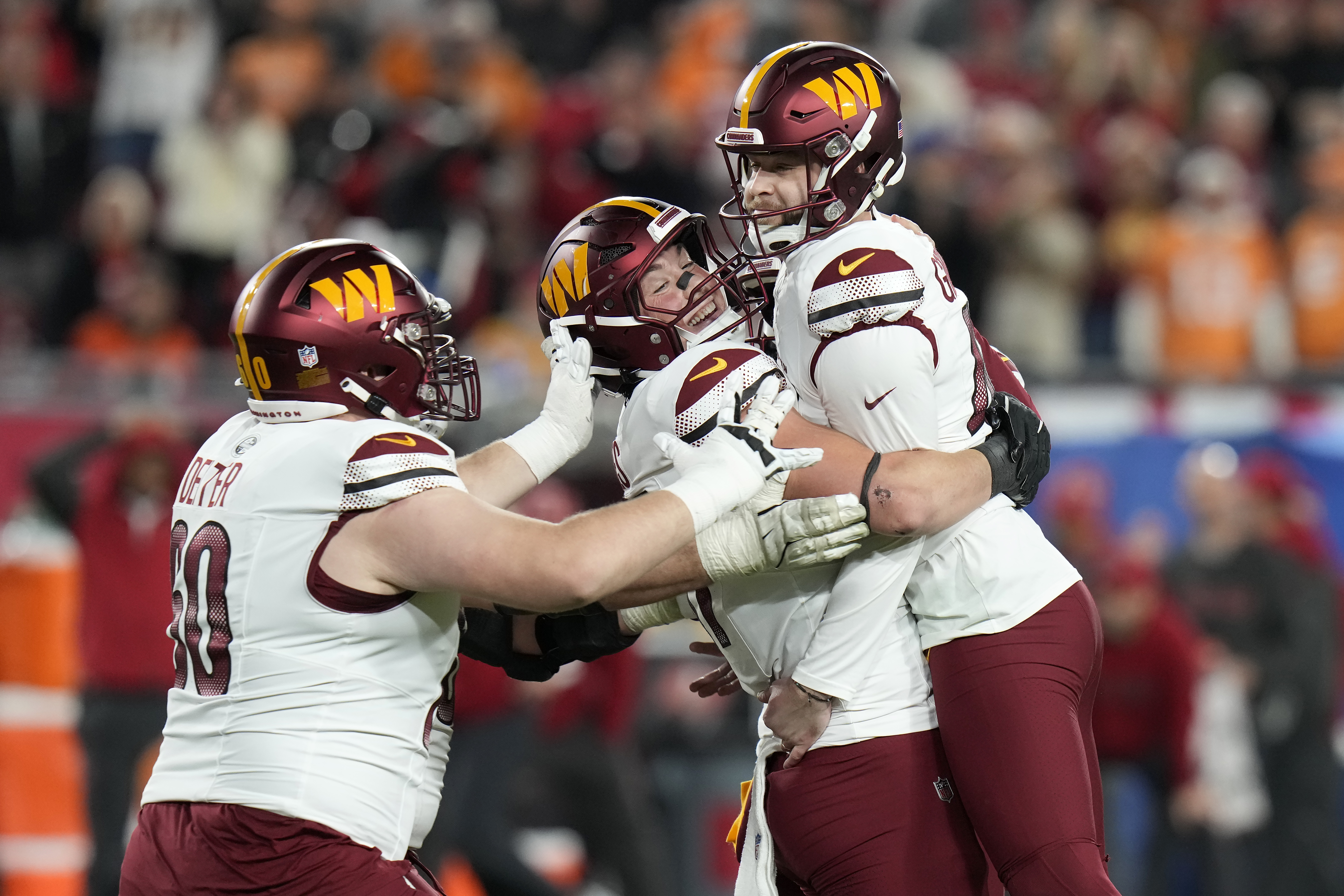 Washington Commanders place kicker Zane Gonzalez, right, is congratulated by teammates after kicking the game winning field goal against the Tampa Bay Buccaneers during the second half of an NFL wild-card playoff football game in Tampa, Fla., Sunday, Jan. 12, 2025.
