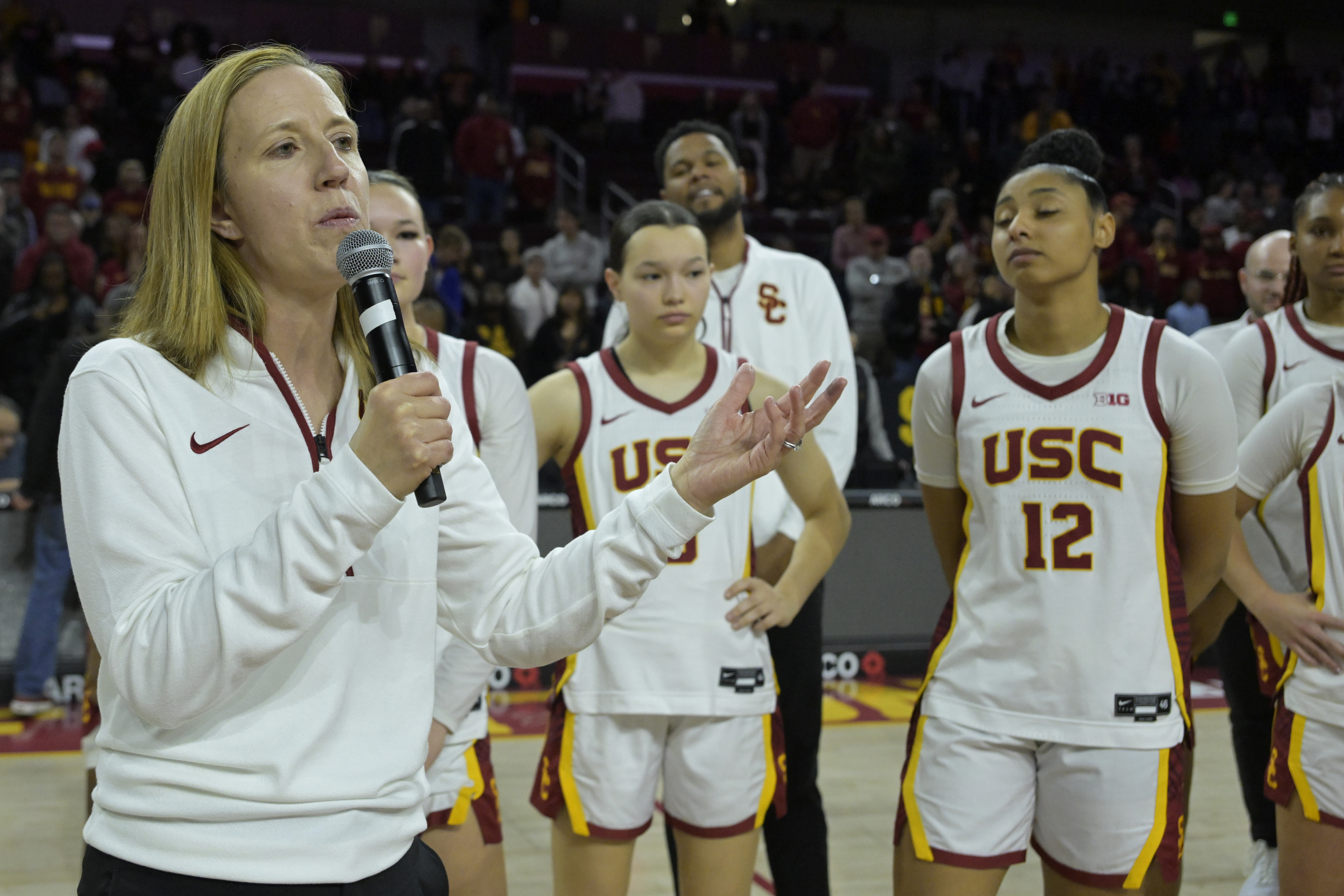Southern California head coach Lindsay Gottlieb, left, speaks to fans and thanks them for attending in light of recent wildfires following an NCAA college basketball game against Penn State, Sunday, Jan. 12, 2025, in Los Angeles.