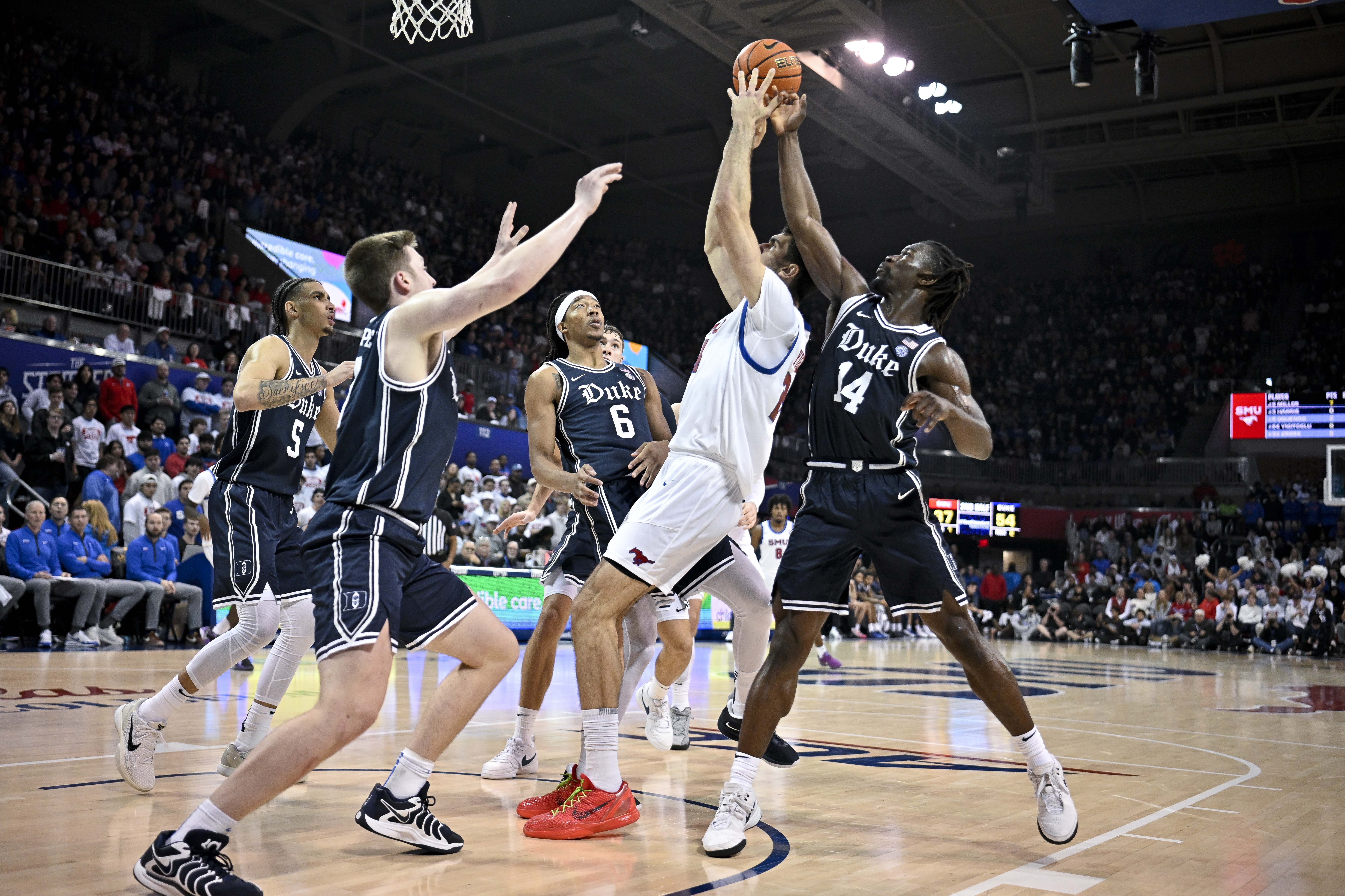 SMU center Samet Yigitoglu (24) and Duke guard Sion James (14) battle for control of the ball as guard Kon Knueppel (7) and guard Tyrese Proctor (5) and forward Maliq Brown (6) look on during the second half of an NCAA college basketball game, Saturday, Jan. 4, 2025, in Dallas. Duke wins 89-62.