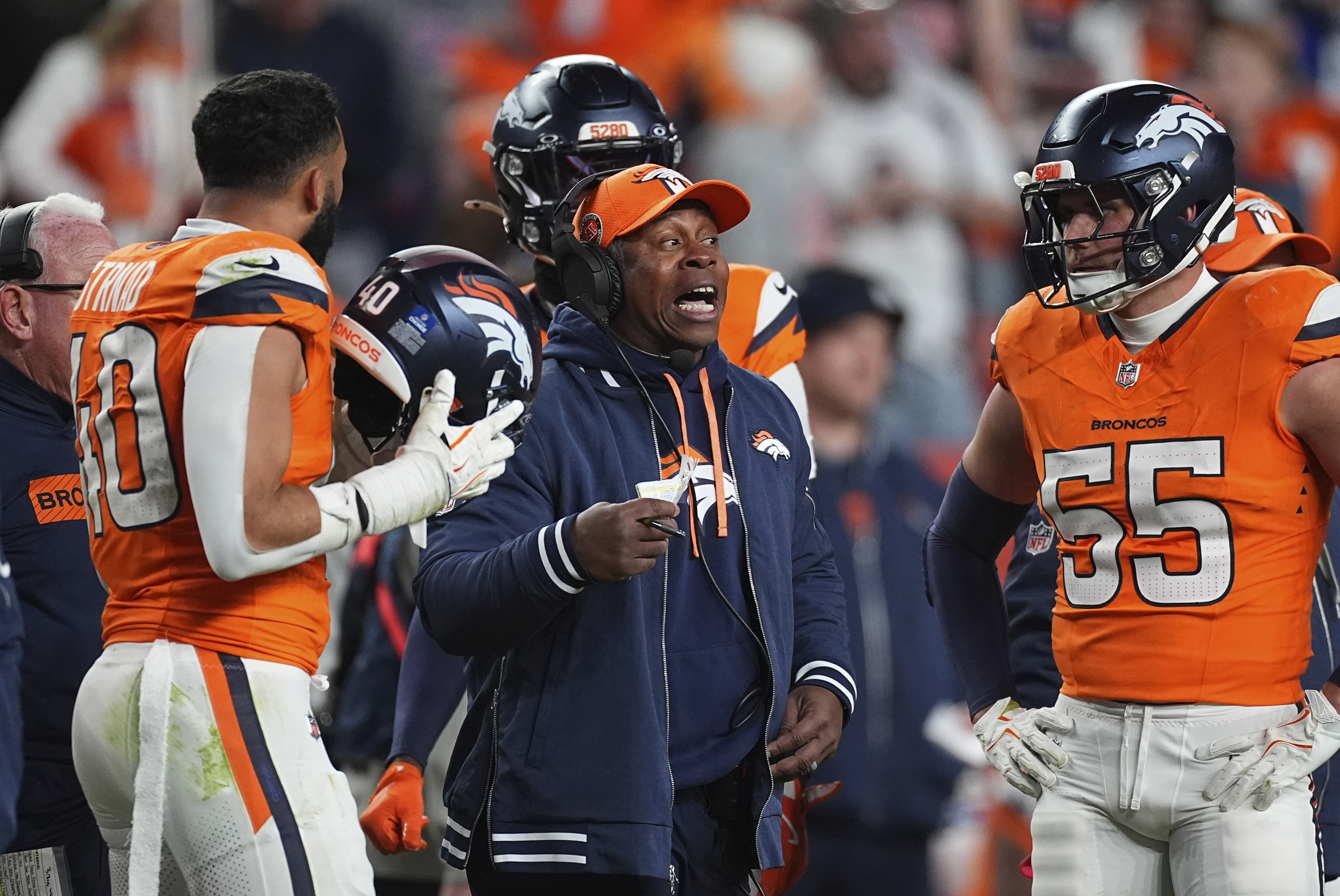 Denver Broncos defensive coordinator Vance Joseph, center, confers with Denver Broncos linebackers Justin Strnad, left, and Cody Barton in the second half of an NFL football game against the Indianapolis Colts Sunday, Dec. 15, 2024, in Denver.