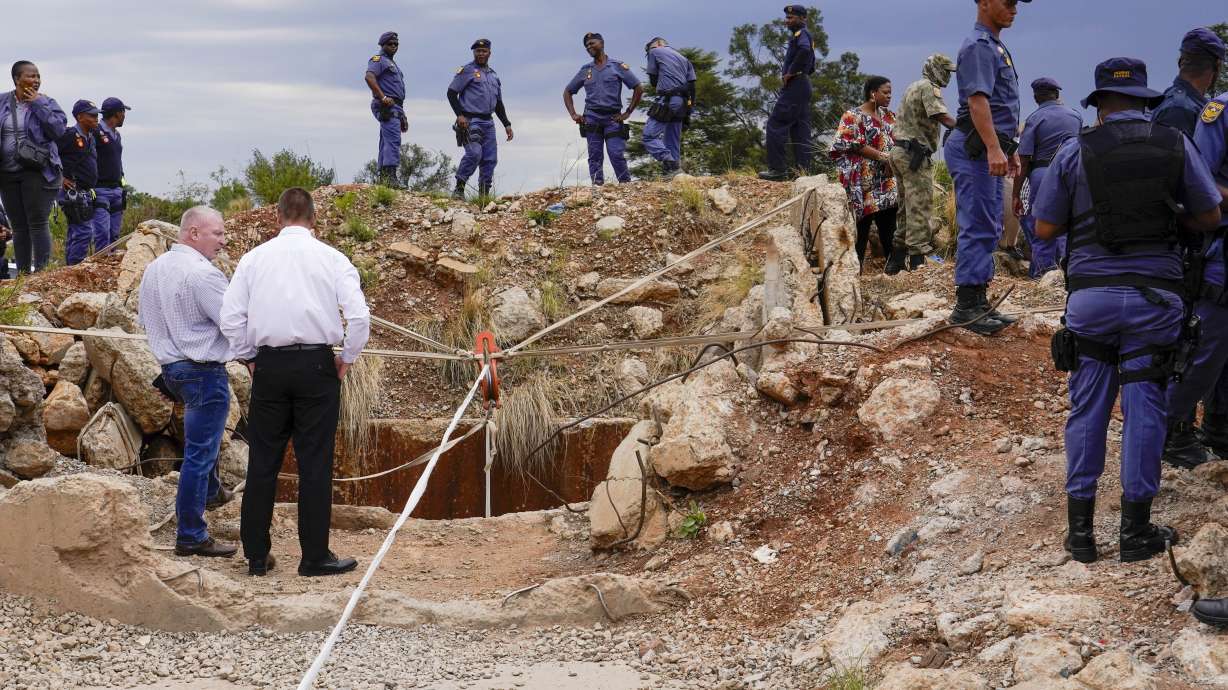 Police officers and private security personnel stand by the opening of a reformed gold mineshaft where miners are trapped in Stilfontein, South Africa, Nov. 15, 2024. At least 100 have died in a mine, a group says.