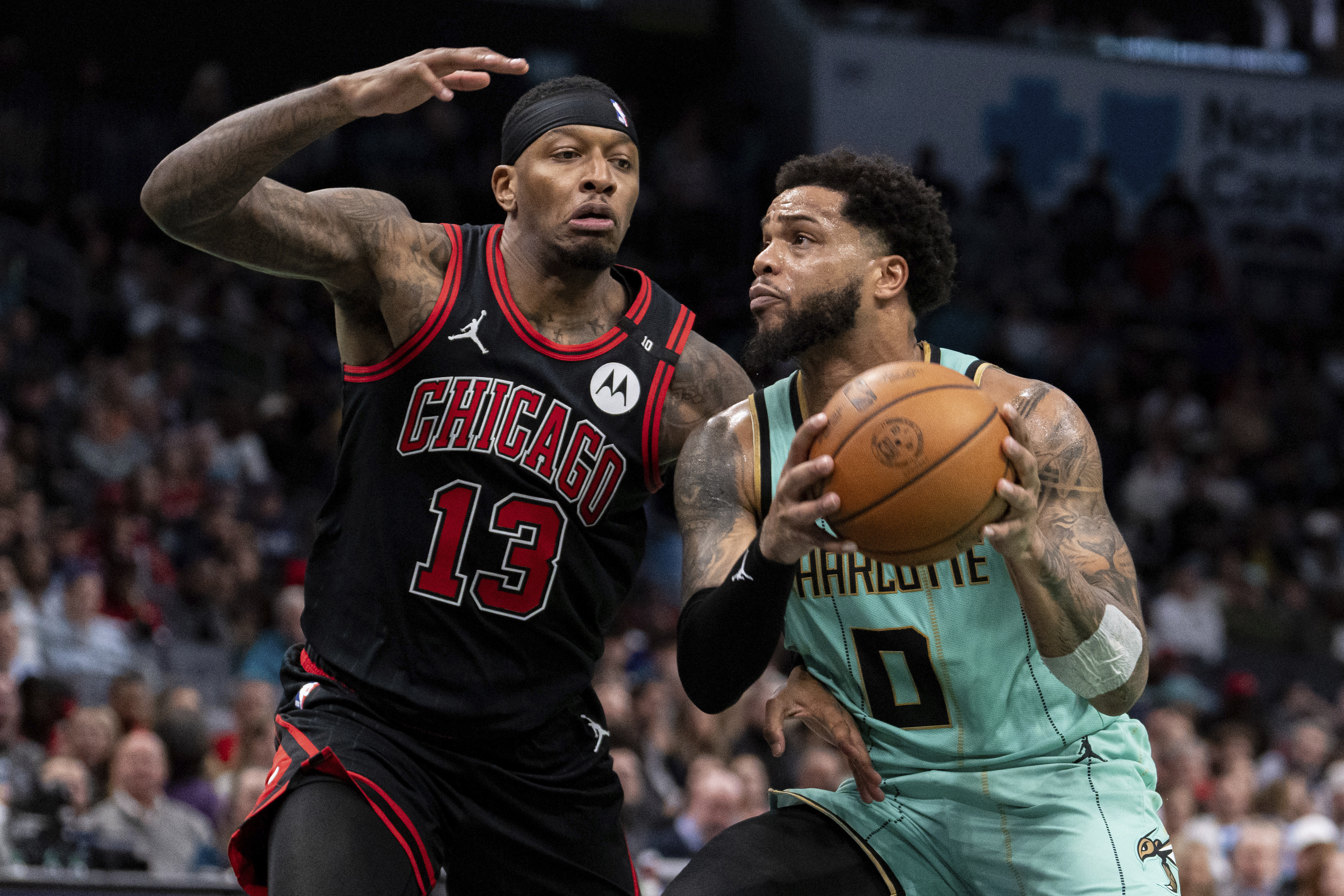 Charlotte Hornets forward Miles Bridges (0) drives to the basket while guarded by Chicago Bulls forward Torrey Craig (13) during the second half of an NBA basketball game in Charlotte, N.C., Monday, Dec. 30, 2024.
