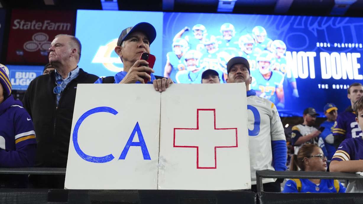 A Los Angeles Rams fan holds a sign b before an NFL wild card playoff football game against the Minnesota Vikings, Monday, Jan. 13, 2025, in Glendale, Ariz.