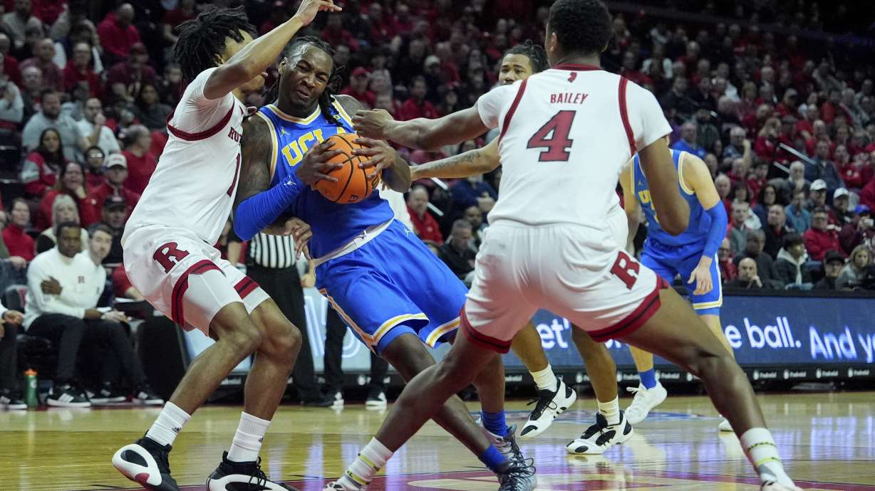 UCLA guard Sebastian Mack, second from left, drives into Rutgers guard Jamichael Davis, left, during the first half of an NCAA college basketball game, Monday, Jan. 13, 2025, in Piscataway, N.J.