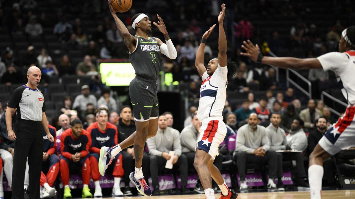 Minnesota Timberwolves forward Jaden McDaniels (3) looks to pass the ball against Washington Wizards guard Bub Carrington, center right, during the first half of an NBA basketball game, Monday, Jan. 13, 2025, in Washington.