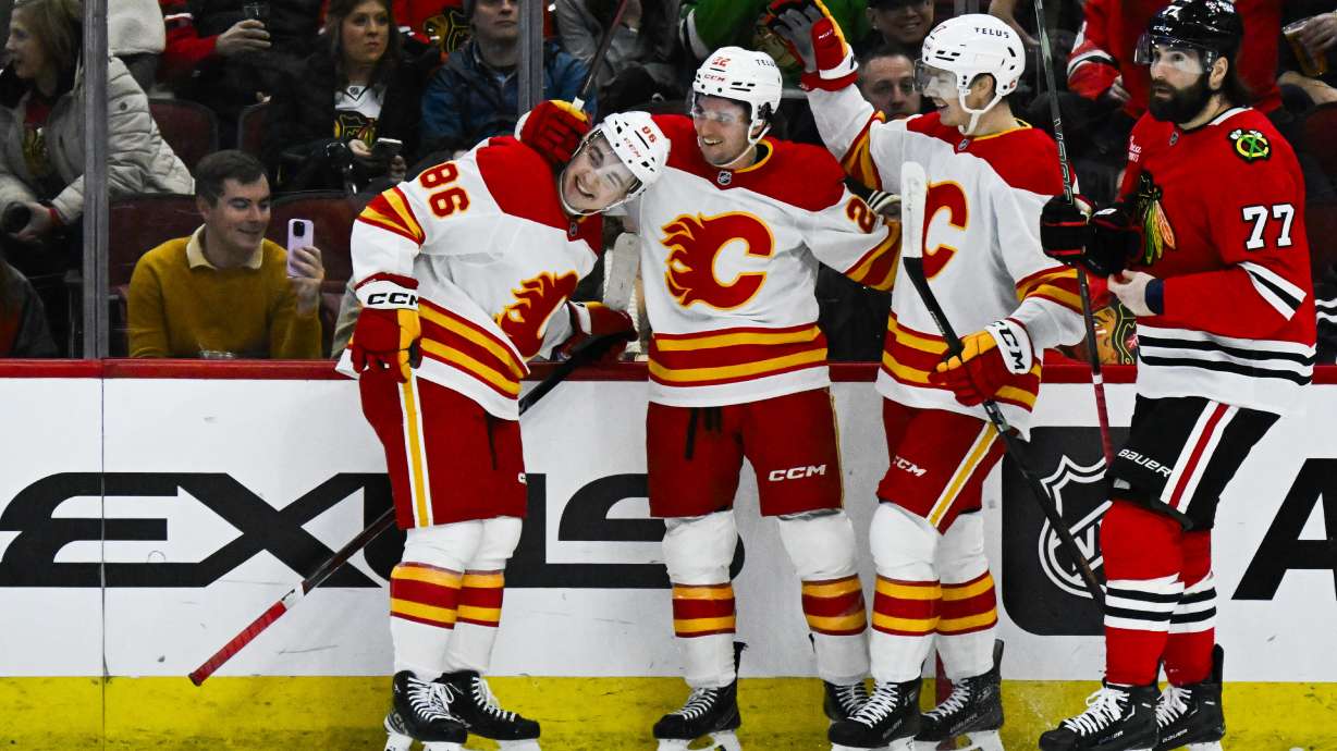 Calgary Flames left wing Jakob Pelletier, center, celebrates his goal against the Chicago Blackhawks with center Rory Kerins (86) and center Yegor Sharangovich, right, during the first period of an NHL hockey game, Monday, Jan. 13, 2025, in Chicago.
