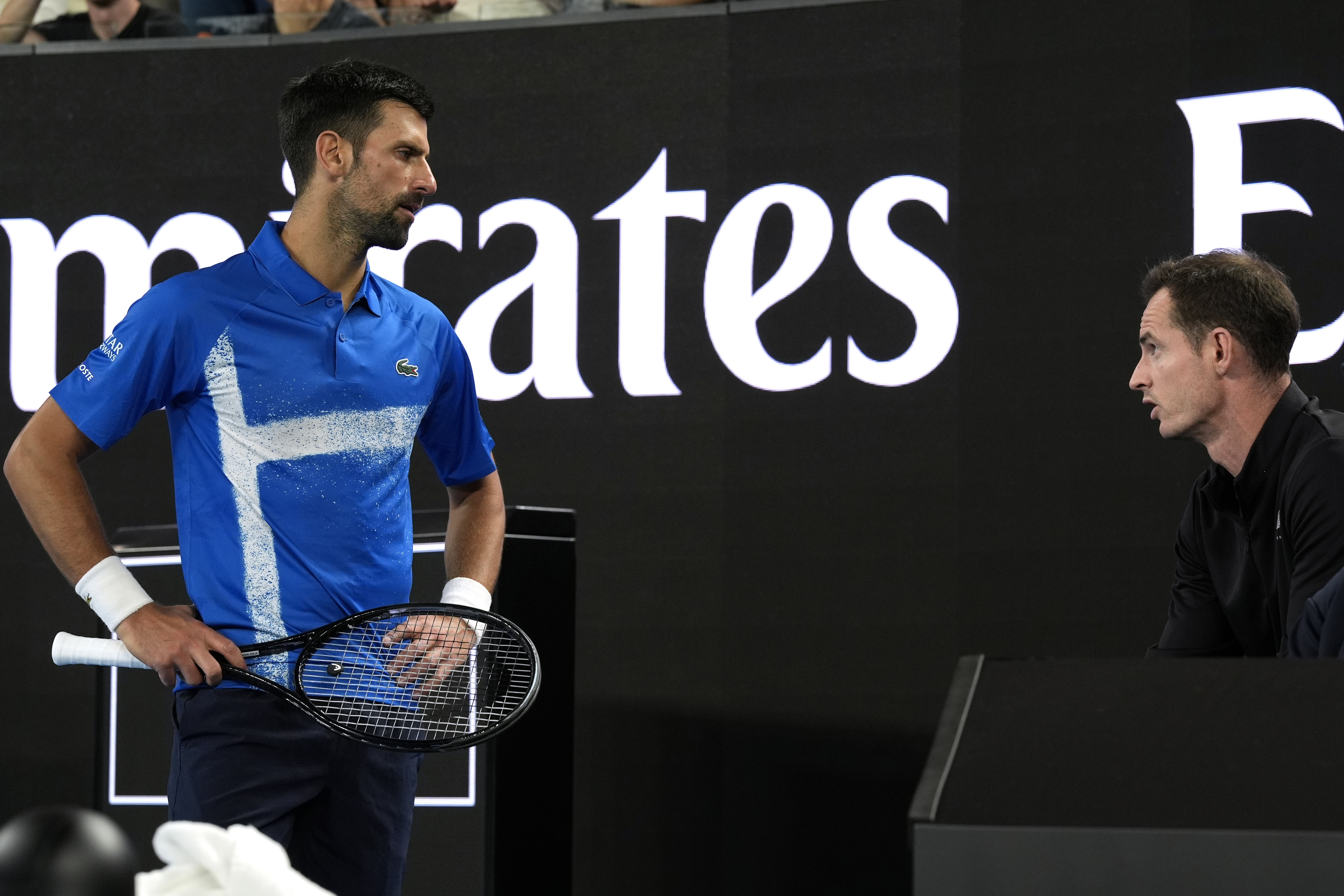 Novak Djokovic, left, of Serbia talks with his coach Andy Murray during his first round match against Nishesh Basavareddy of the U.S. at the Australian Open tennis championship in Melbourne, Australia, Monday, Jan. 13, 2025.