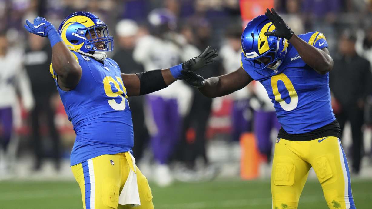 Los Angeles Rams defensive tackle Kobie Turner (91) celebrates his sack of Minnesota Vikings quarterback Sam Darnold with Byron Young (0) during the first half of an NFL wild card playoff football game, Monday, Jan. 13, 2025, in Glendale, Ariz.