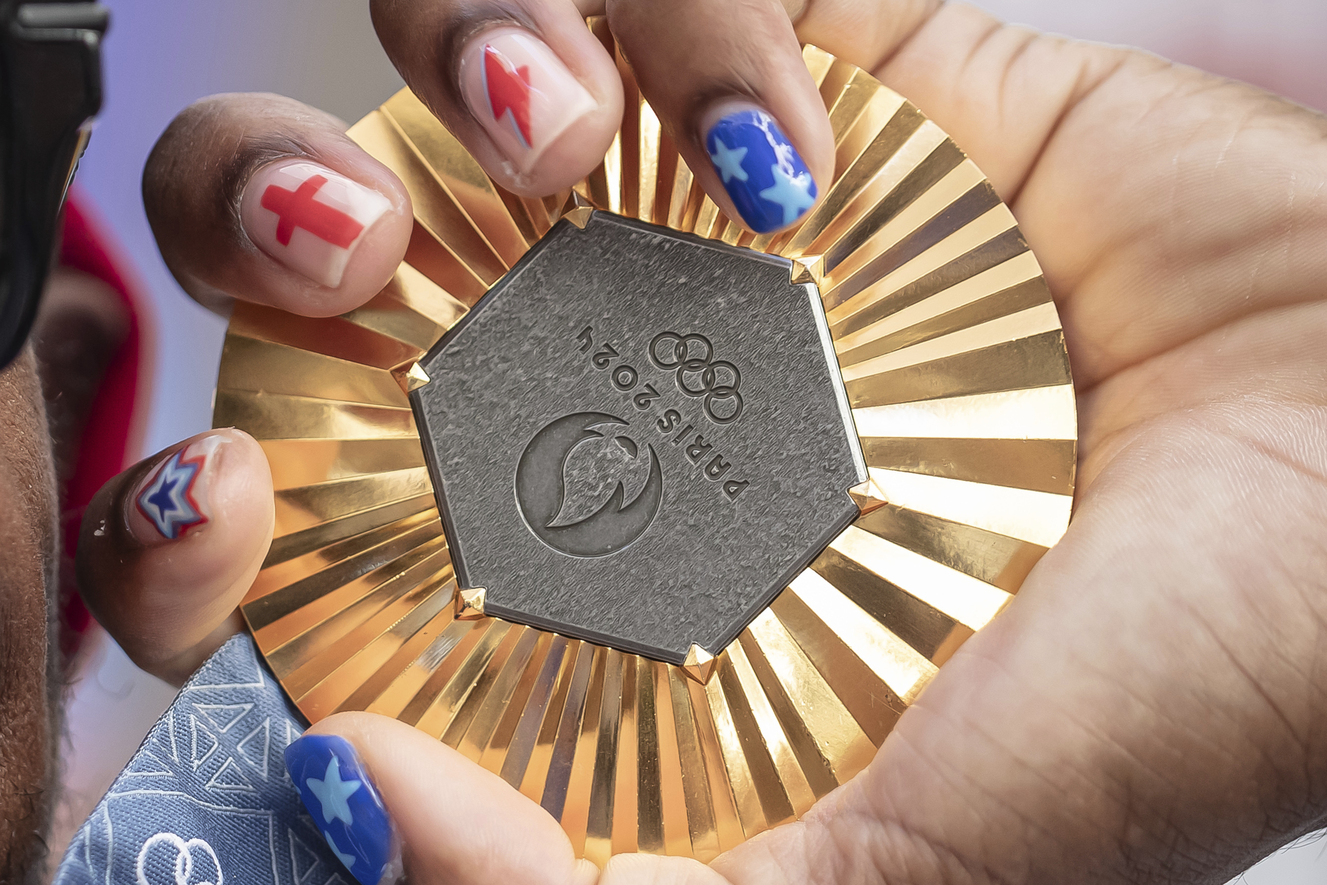 FILE - American Olympic champion Noah Lyles holds this gold medal before an interview in Paris, France, Sunday, Aug. 11, 2024.