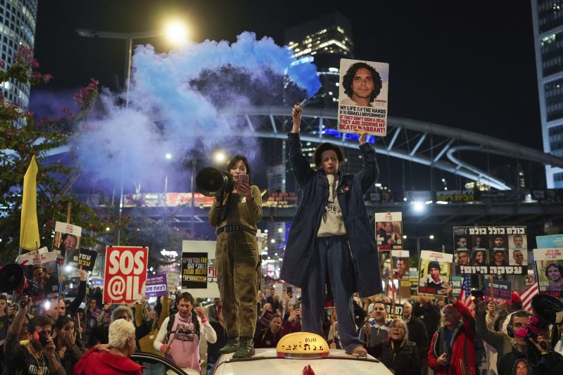 Demonstrators hold signs and flares during a protest calling for the immediate release of the hostages held in the Gaza Strip by the Hamas militant group in Tel Aviv, Israel, on Monday.