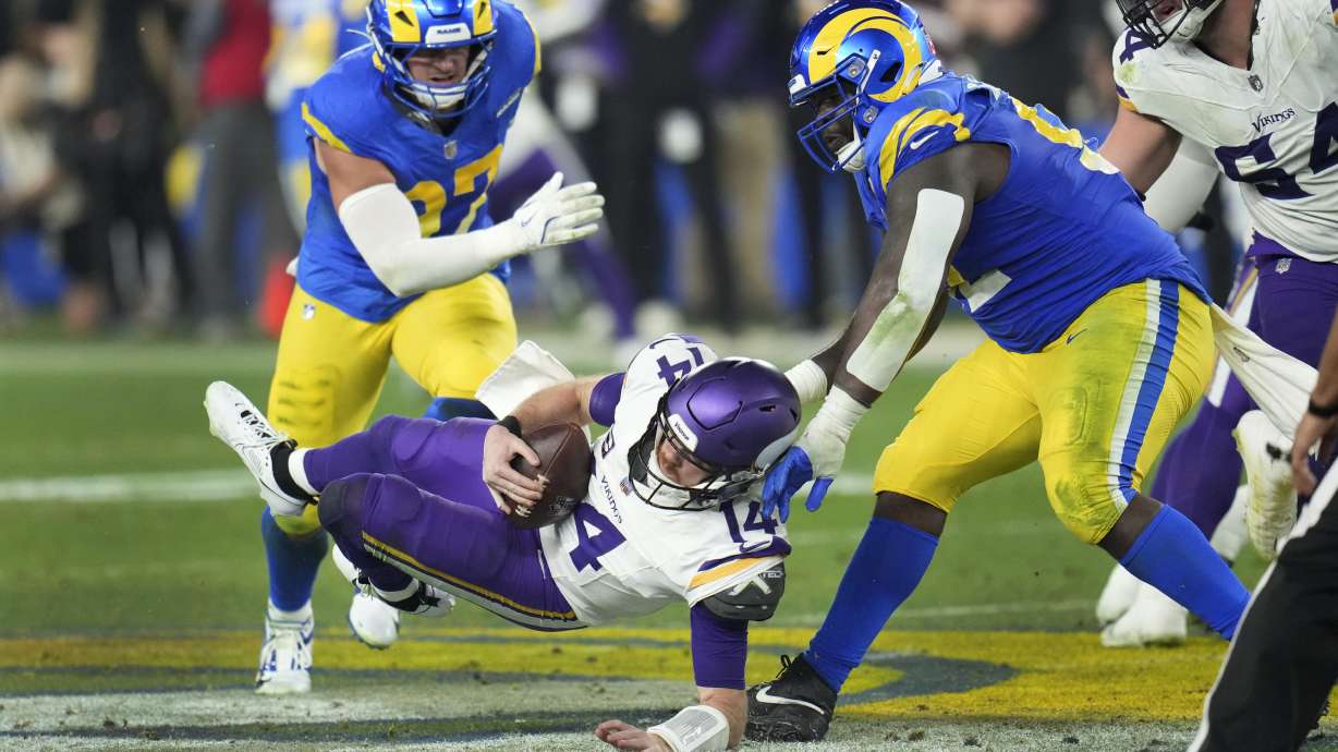 Los Angeles Rams defensive tackle Neville Gallimore (92) sacks Minnesota Vikings quarterback Sam Darnold (14) during the second half of an NFL wild card playoff football game, Monday, Jan. 13, 2025, in Glendale, Ariz.