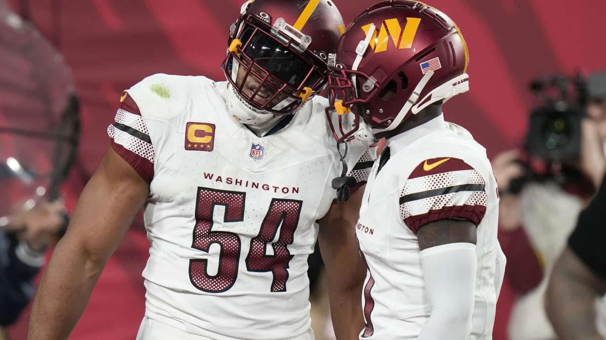 Washington Commanders linebacker Bobby Wagner (54) is congratulated by cornerback Mike Sainristil after recovering a fumble by Tampa Bay Buccaneers quarterback Baker Mayfield during the second half of an NFL wild-card playoff football game in Tampa, Fla., Sunday, Jan. 12, 2025.