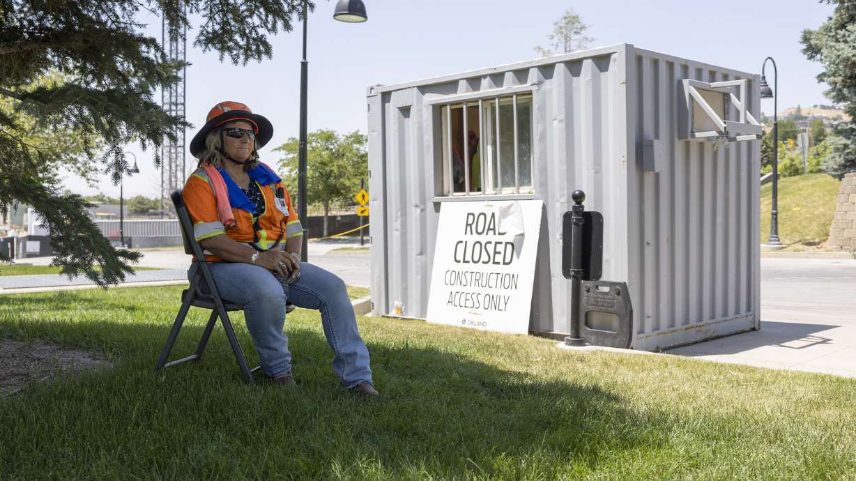 Construction Gatekeeper Cindy Bithell sits in the shade to beat the heat, in Salt Lake City on July 11, 2024. Salt Lake County was one of 10 Utah counties that broke an average temperature record last year.