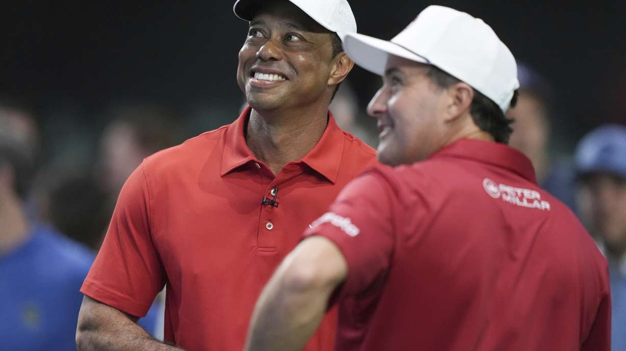 Tiger Woods, left, talks to his Jupiter Link Golf Club teammate Kevin Kisner before the start of a match against the Los Angeles Golf Club, Tuesday, Jan. 14, 2025, in Palm Beach Gardens, Fla.