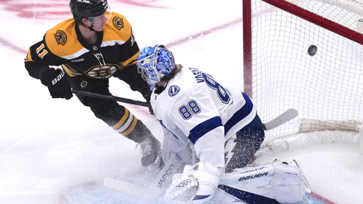Boston Bruins center Trent Frederic (11) flips the puck past Tampa Bay Lightning goaltender Andrei Vasilevskiy (88) for a goal during the first period of an NHL hockey game, Tuesday, Jan. 14, 2025, in Boston.