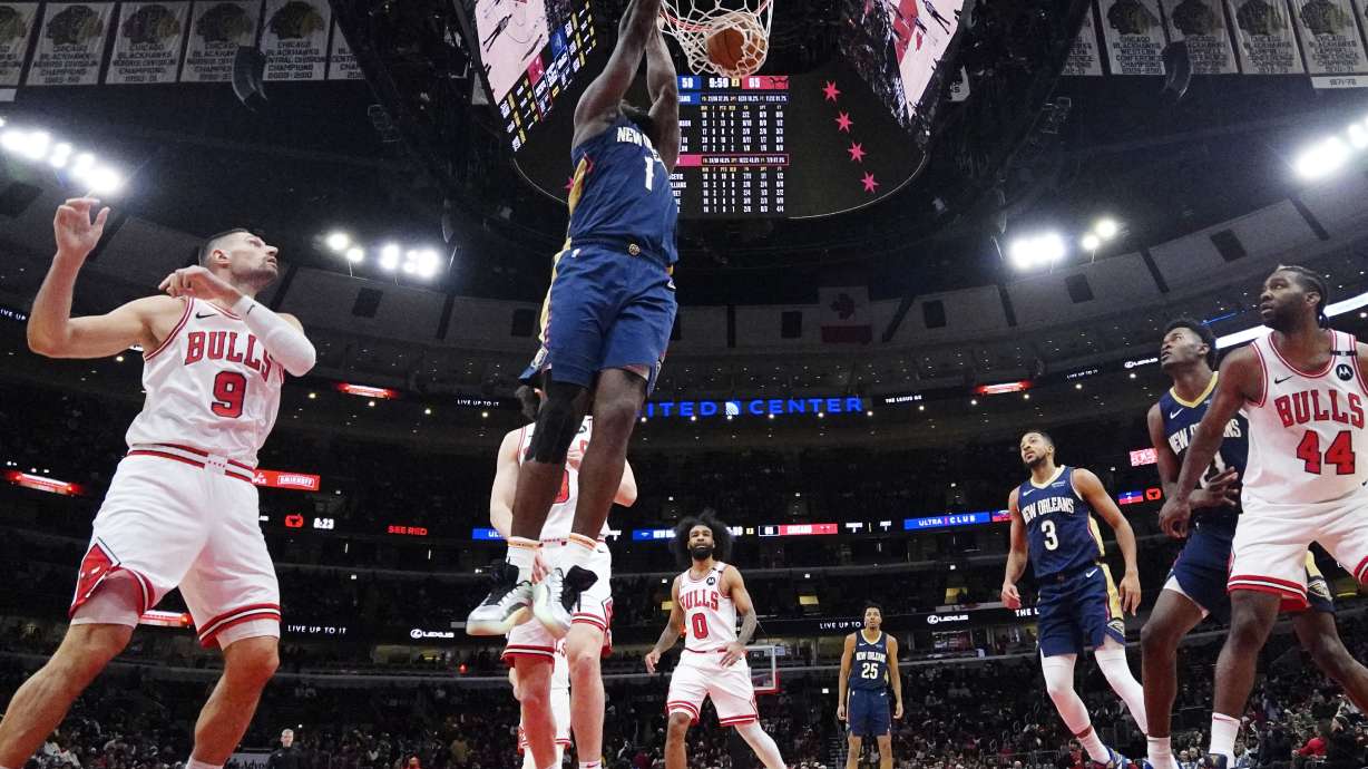 New Orleans Pelicans forward Zion Williamson (1) hangs from the rim after dunking during the second half of an NBA basketball game against the Chicago Bulls in Chicago, Tuesday, Jan. 14, 2025. The Pelicans won 119-113.