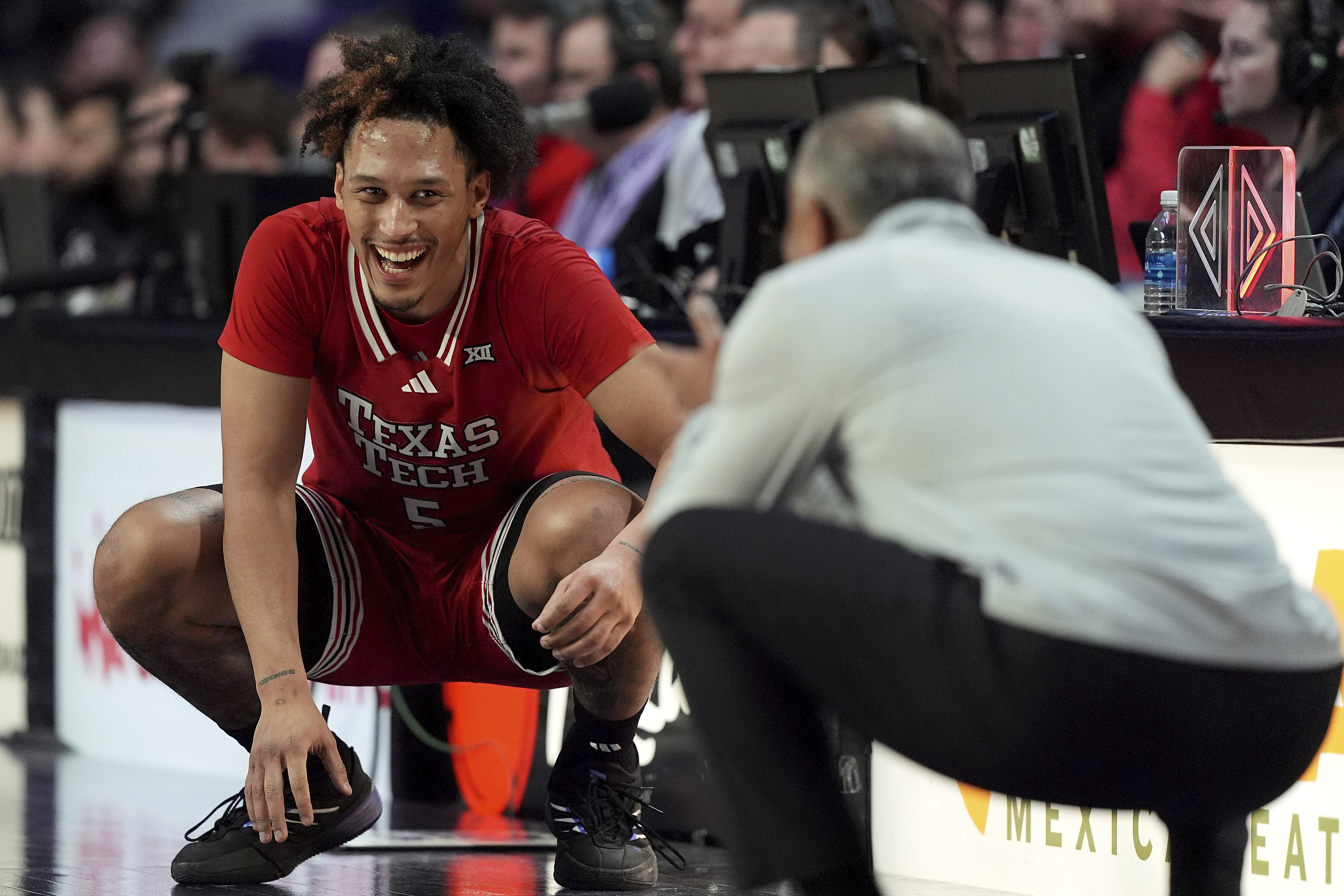 Texas Tech forward Darrion Williams (5) chats with Kansas State head coach Jerome Tang as he waits to go into the game during the second half of an NCAA college basketball game, Tuesday, Jan. 14, 2025, in Manhattan, Kan. Texas Tech won 61-57.