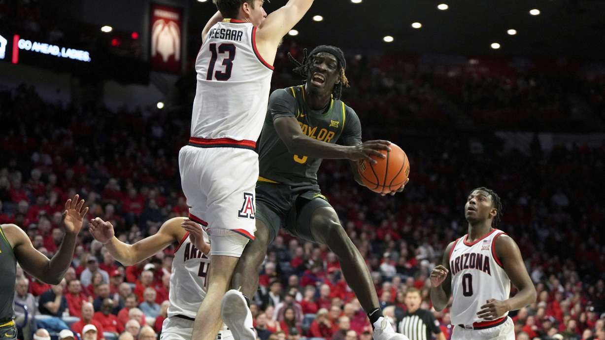 Baylor forward Jason Asemota drives between Arizona forward Trey Townsend, forward Henri Veesaar, and guard Jaden Bradley (0) during the first half of an NCAA college basketball game, Tuesday, Jan. 14, 2025, in Tucson, Ariz.