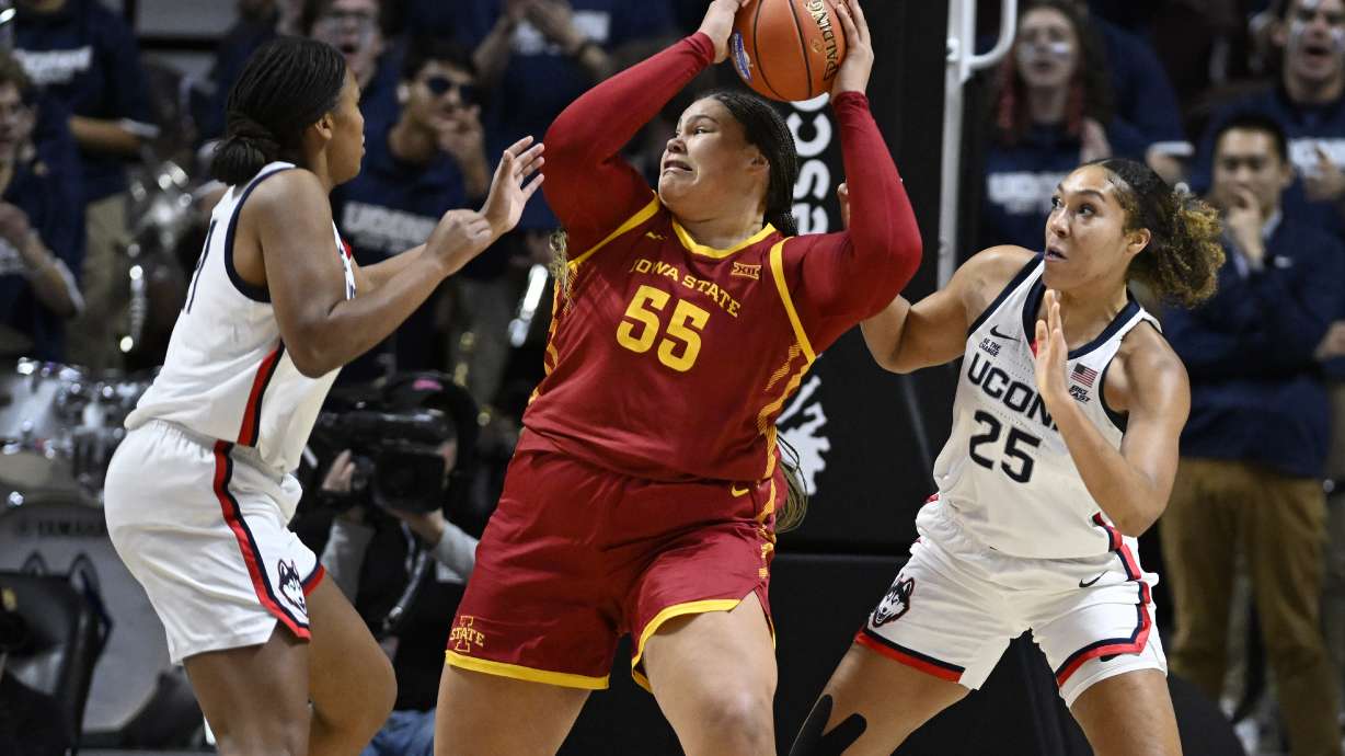 Iowa State center Audi Crooks is guarded by UConn forwards Sarah Strong, left, and Ice Brady, right, in the first half of an NCAA college basketball game, Tuesday, Dec. 17, 2024, in Uncasville, Conn.