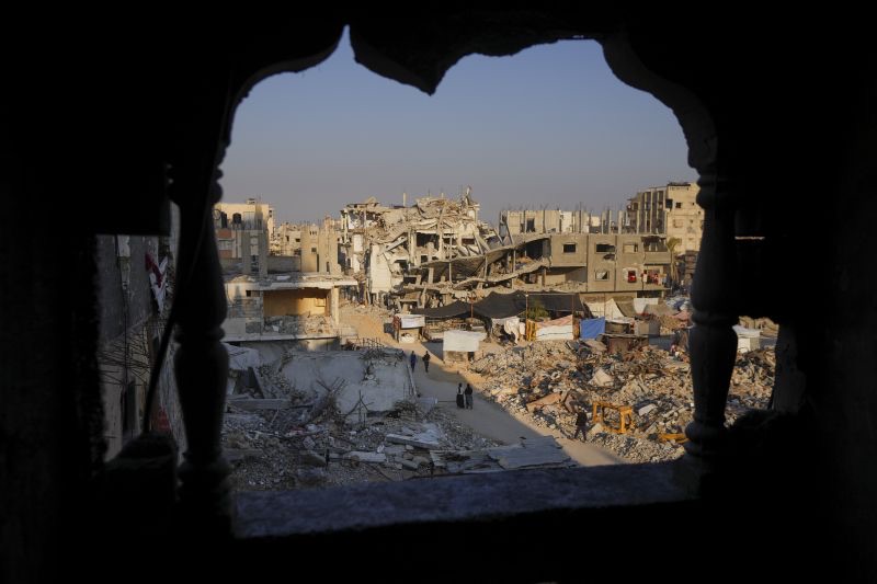 Palestinians walk through the destruction in the wake of an Israeli air and ground offensive in Khan Younis, southern Gaza Strip, on Jan. 7.