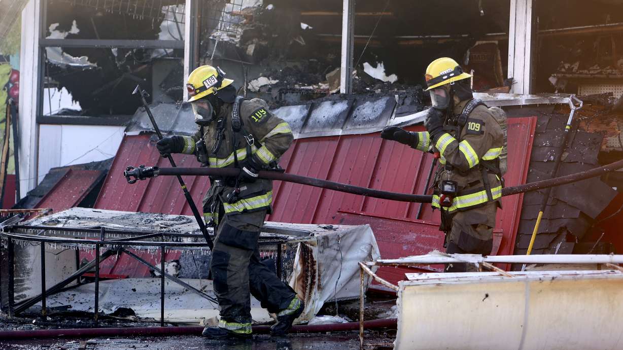 Unified firefighters work at the scene of a fire that destroyed La Placita Market in Kearns on Wednesday.