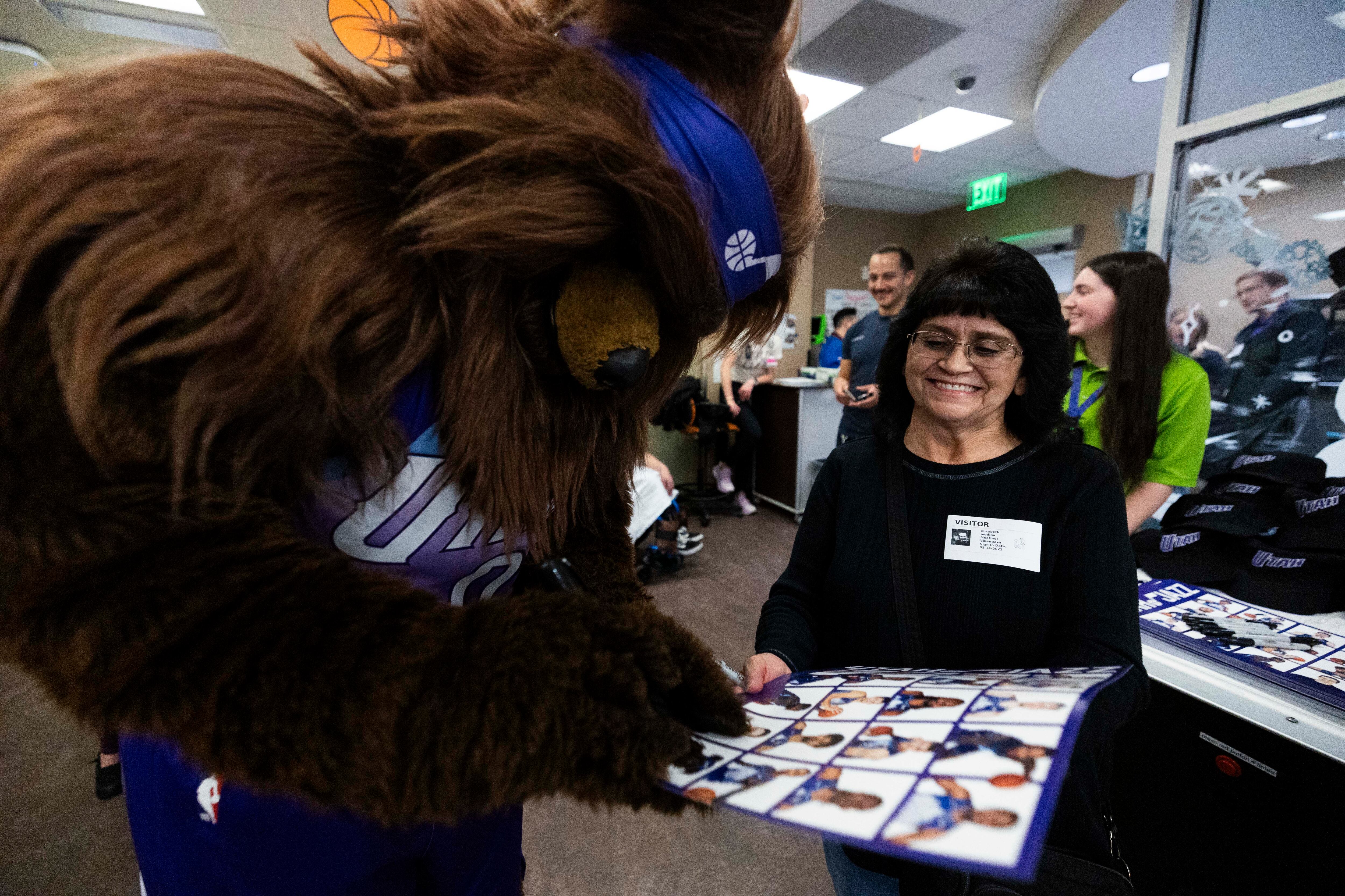 Jazz Bear signs a poster for Liz Medina during a Utah Jazz team visit to Intermountain Primary Children’s Hospital in Salt Lake City on Tuesday.