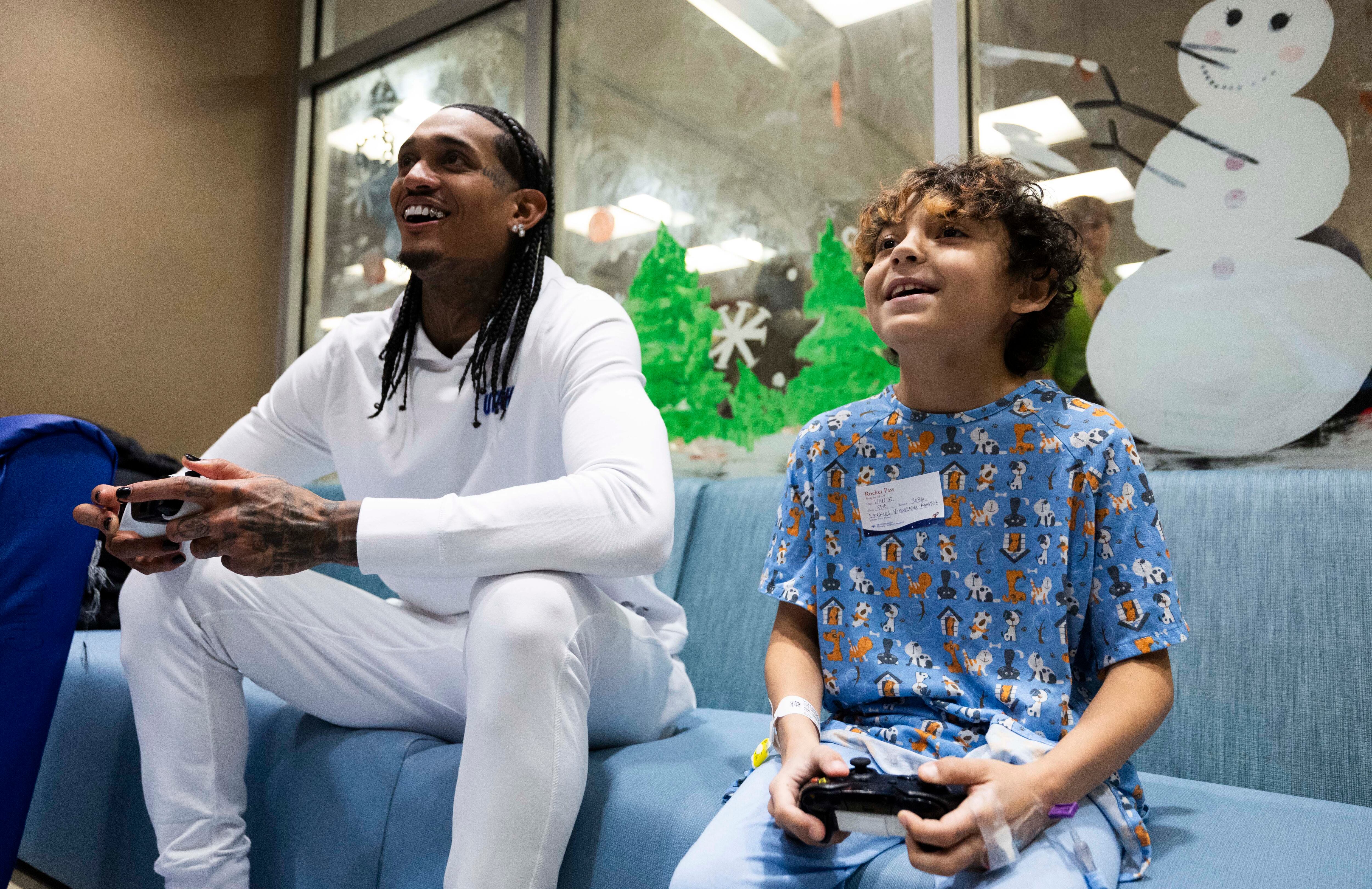 Ezekiel Villanueva-Ramirez, 9, right, smiles while playing Madden 23 with Utah Jazz guard Jordan Clarkson during a Utah Jazz visit to Intermountain Primary Children’s Hospital in Salt Lake City on Tuesday.