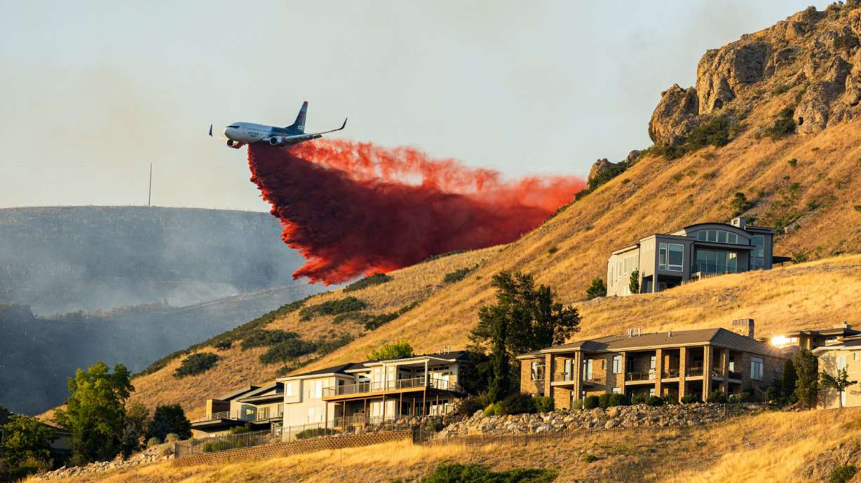A plane drops fire retardant as the Sandhurst Fire burns above Ensign Peak north of Salt Lake City on July 20, 2024.