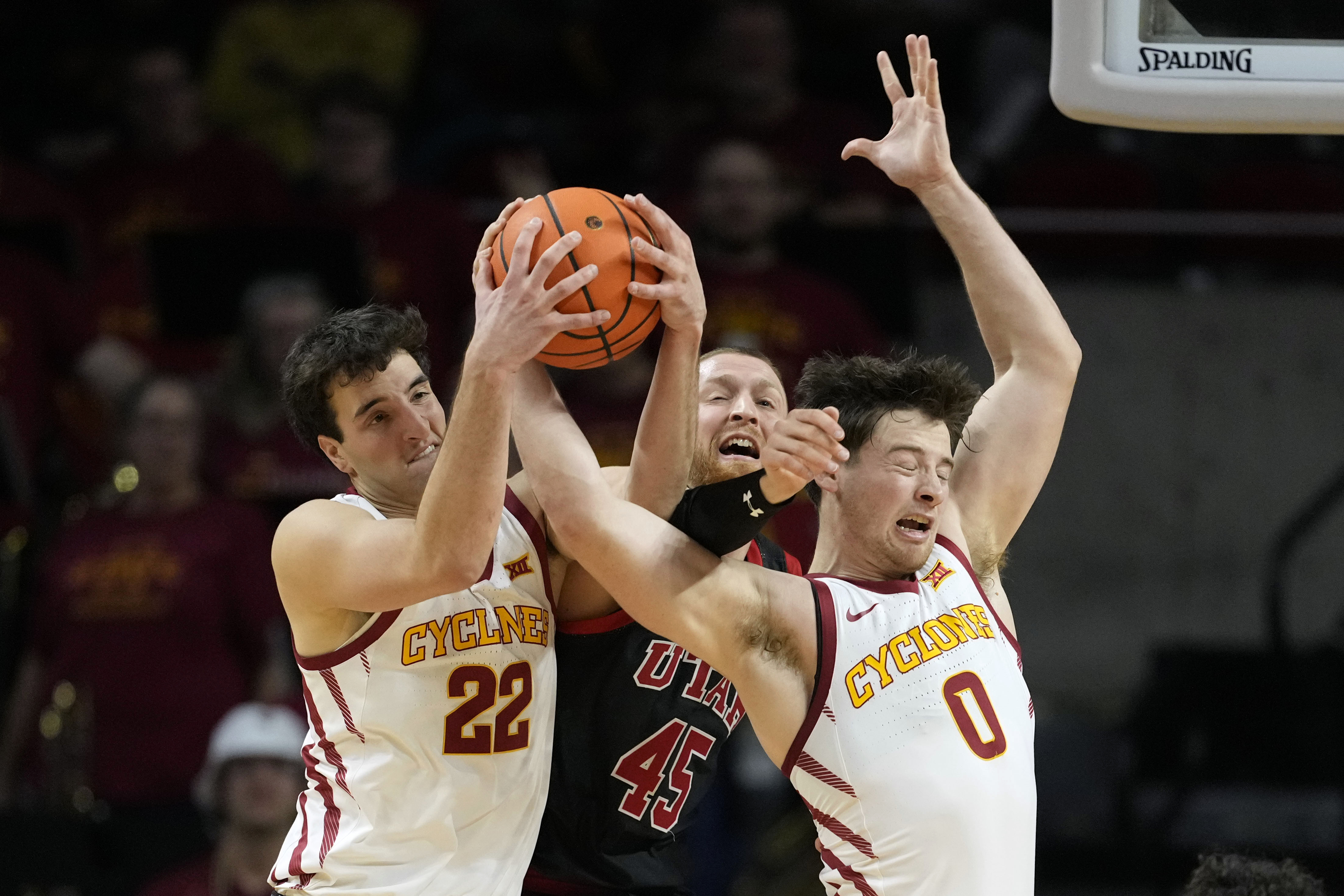 Iowa State forward Milan Momcilovic (22) and guard Nate Heise (0) fight for a rebound with Utah guard Mason Madsen (45) during the second half of an NCAA college basketball game Tuesday, Jan. 7, 2025, in Ames, Iowa.