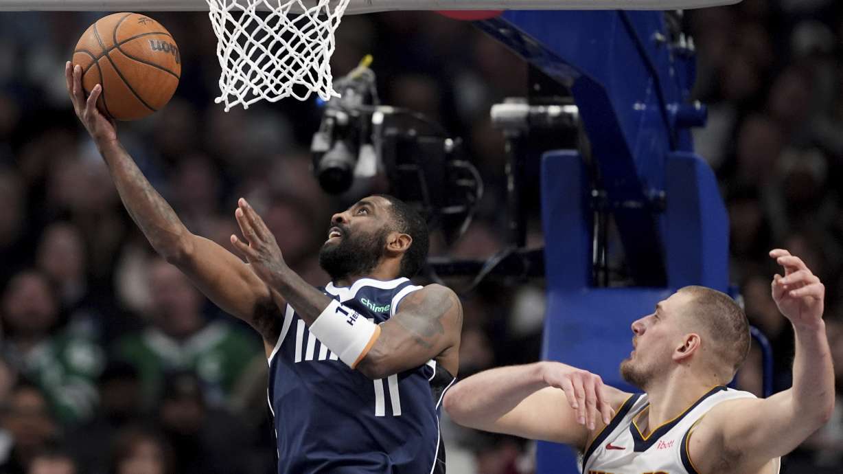 Dallas Mavericks guard Kyrie Irving (11) goes up for a shot as Denver Nuggets' Nikola Jokic, right, defends in the second half of an NBA basketball game in Dallas, Tuesday, Jan. 14, 2025.
