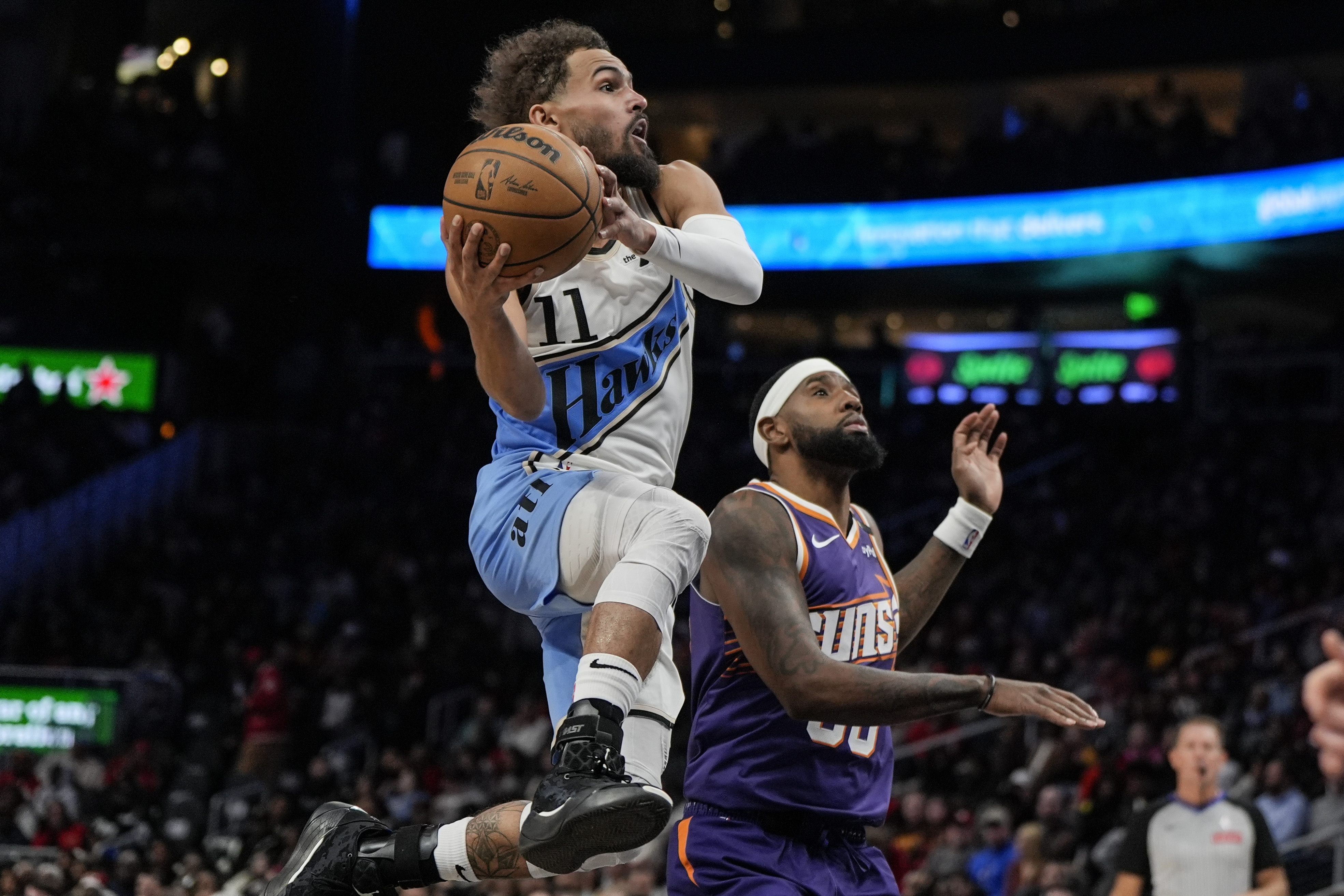 Atlanta Hawks guard Trae Young (11) shoots against Phoenix Suns forward Royce O'Neale (00) during the second half of an NBA basketball game, Tuesday, Jan. 14, 2025, in Atlanta.