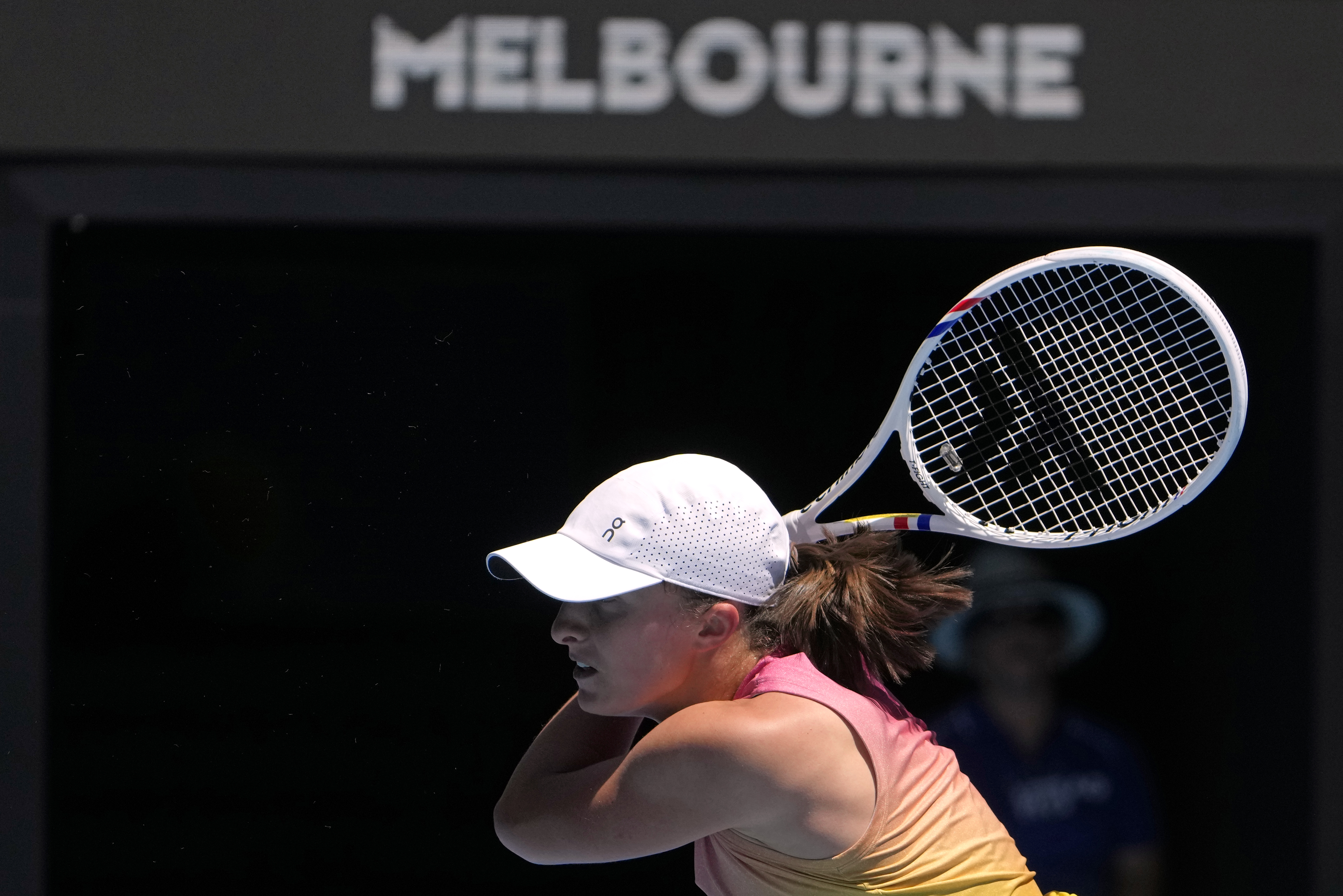 Iga Swiatek of Poland plays a backhand return to Rebecca Sramkova of Slovakia during their second round match at the Australian Open tennis championship in Melbourne, Australia, Thursday, Jan. 16, 2025.